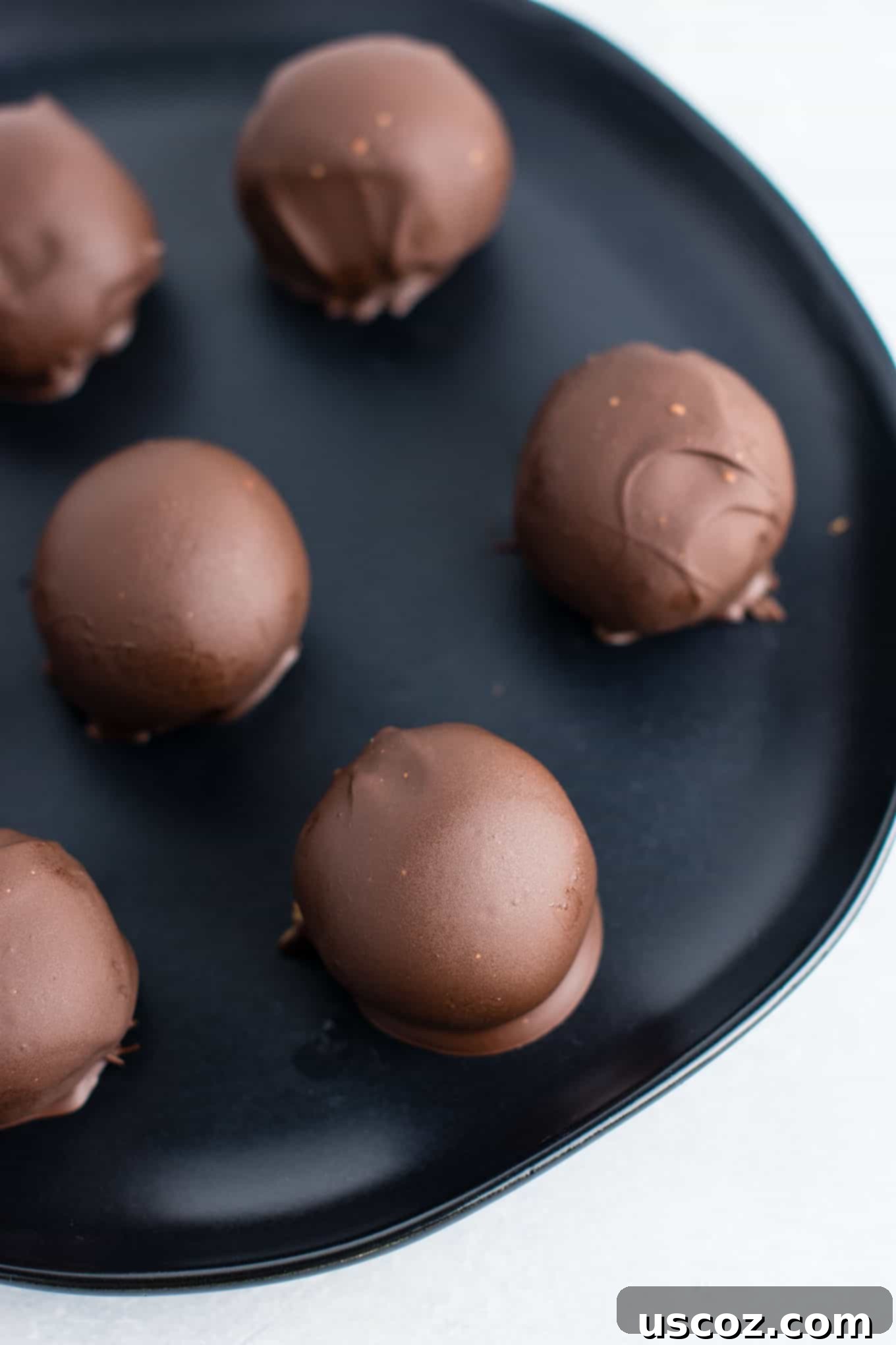 Decadent Yet Healthy No-Bake Peanut Butter Truffles 5 Peanut butter truffle balls chilling on a parchment-lined baking sheet before dipping.
