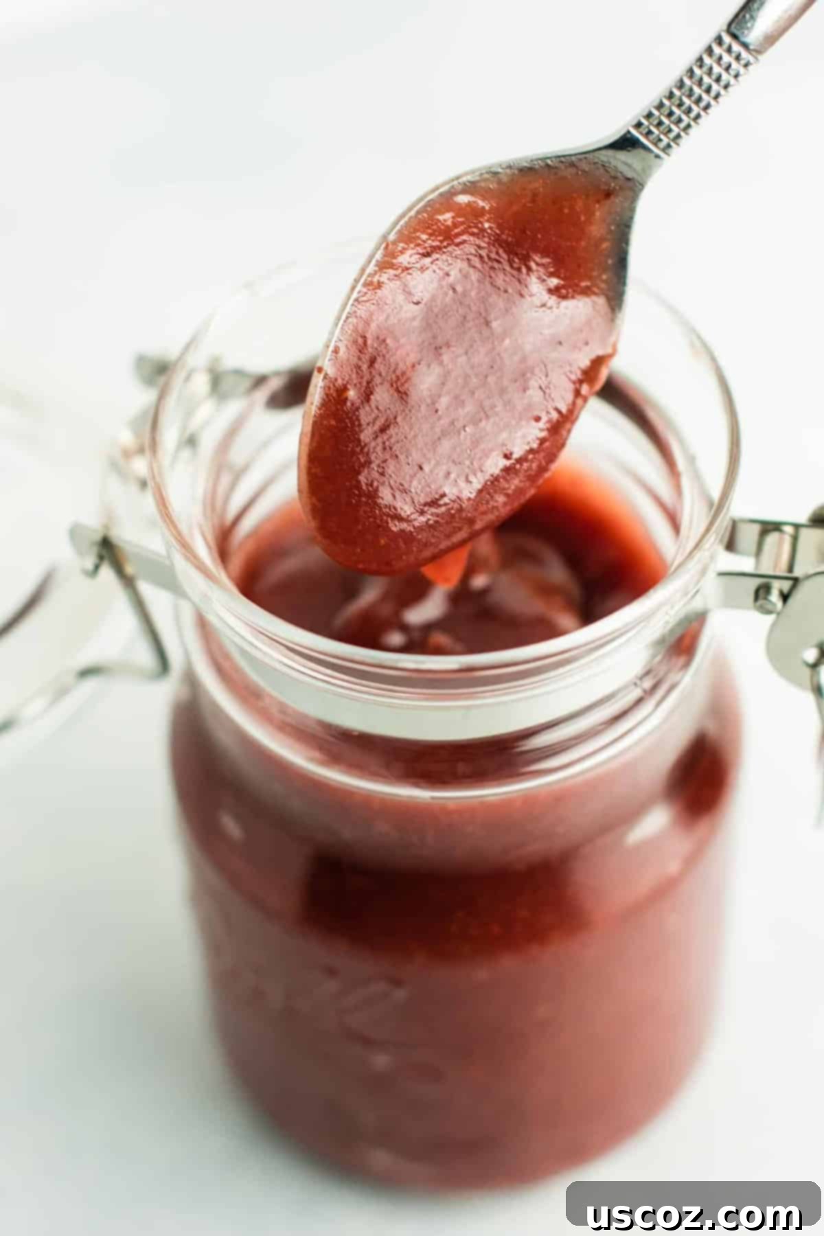 Ultimate Slow Cooker Cranberry Apple Butter 2 A beautiful glass jar of homemade Slow Cooker Cranberry Apple Butter, ready for serving.