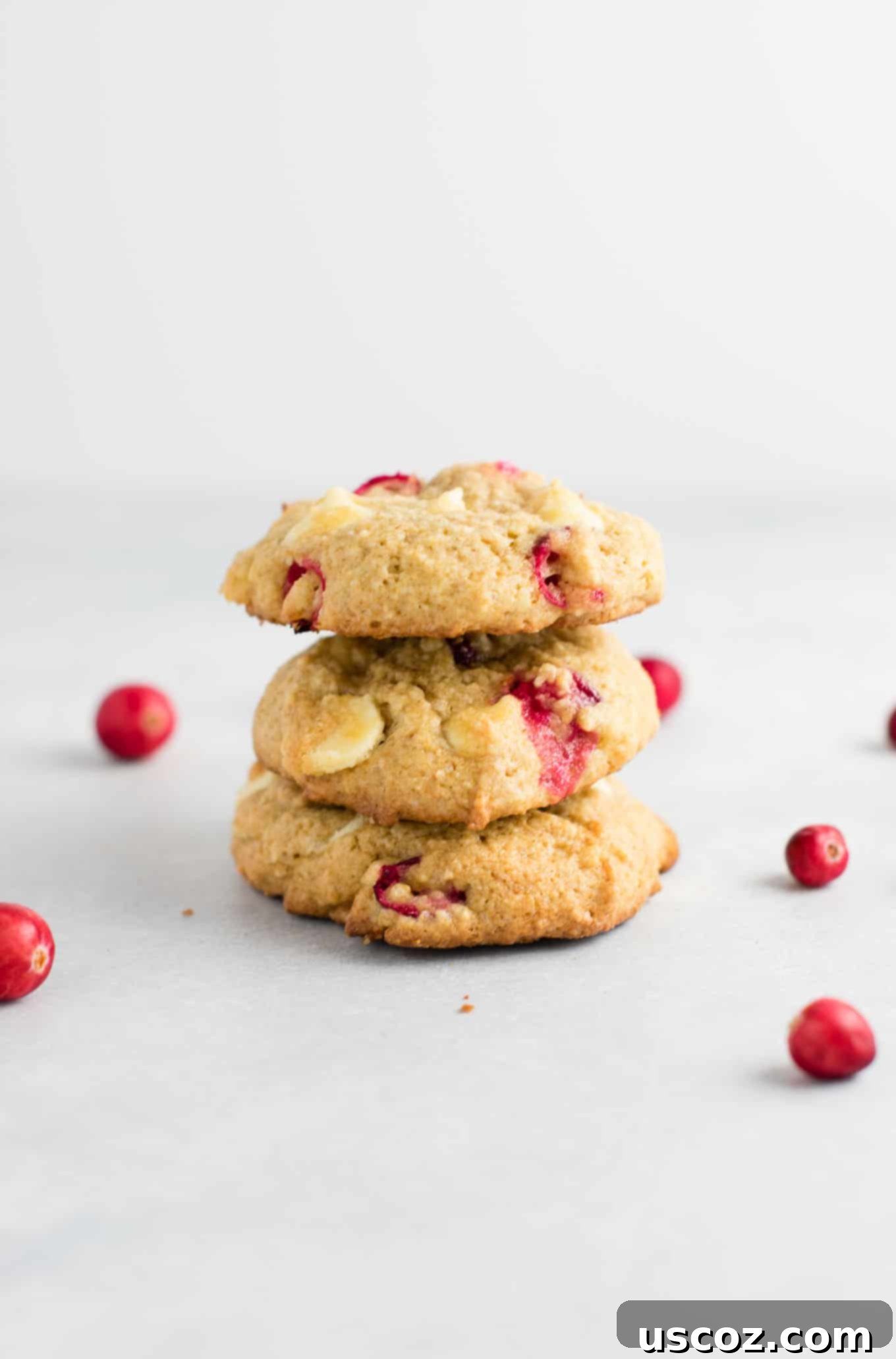 Delightful Cranberry White Chocolate Chip Cookies 2 Stacked cranberry white chocolate chip cookies with a sprinkle of sugar, highlighting their chewy texture and festive appearance.