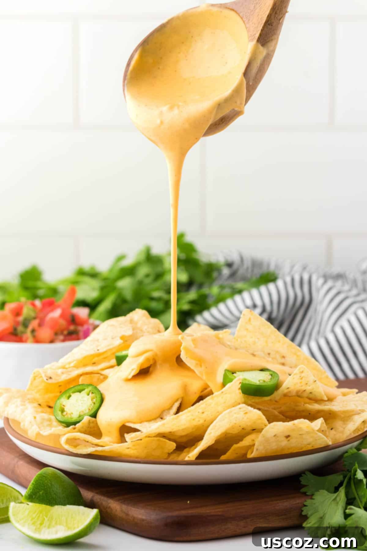 Cheesy Nacho Dip in Minutes 12 pouring nacho cheese sauce over chips