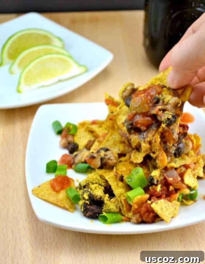 Plant-Powered Taco Bake 2 Delicious and hearty vegan taco casserole with layers of tortilla chips, beans, salsa, and nutritional yeast, ready to be served