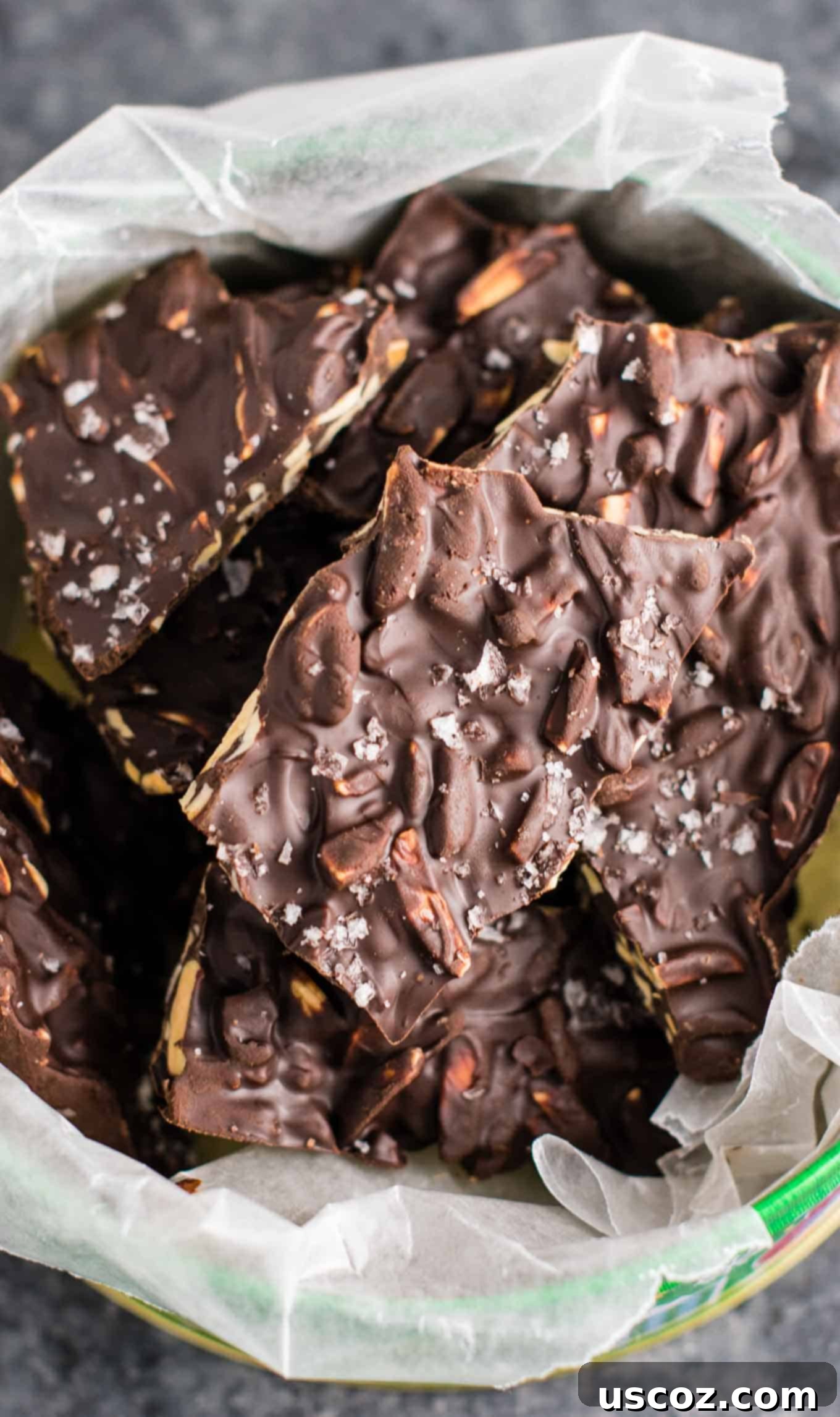 Decadent Dark Chocolate Almond Bark 11 A large collection of dark chocolate almond bark pieces artfully arranged, some with visible sea salt flakes, ready to be enjoyed.