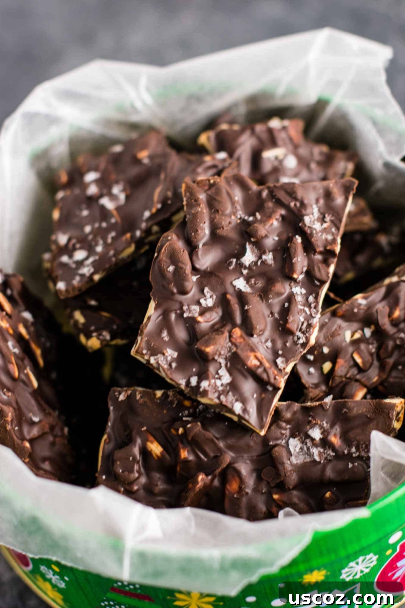 Decadent Dark Chocolate Almond Bark 3 Another view of the festive dark chocolate almond bark in a Christmas tin, showcasing its appealing texture and rich color.