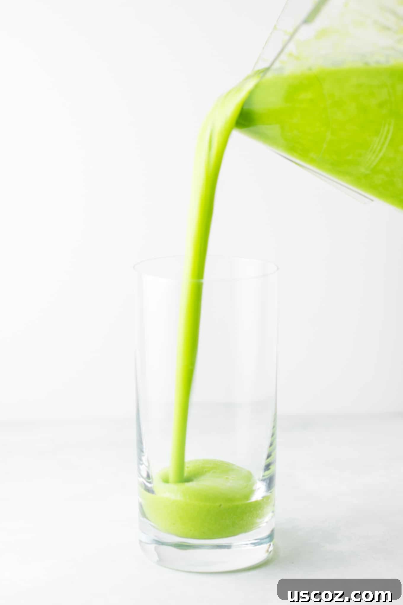 Vibrant Citrus Kale Green Smoothie 3 pouring the green smoothie into a glass