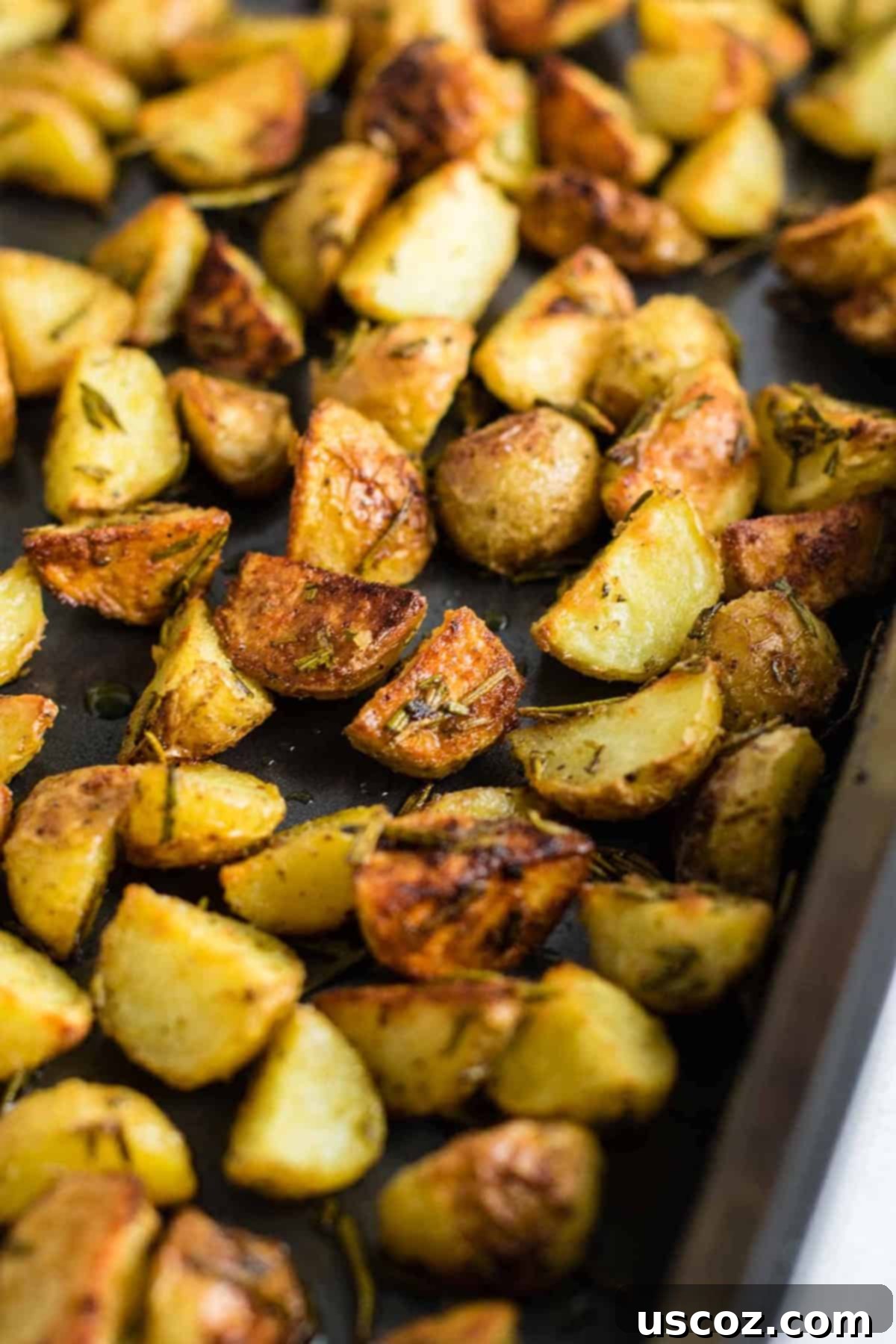Close-up of fresh rosemary sprigs neatly arranged on a wooden cutting board, highlighting their texture and readiness for preparation.