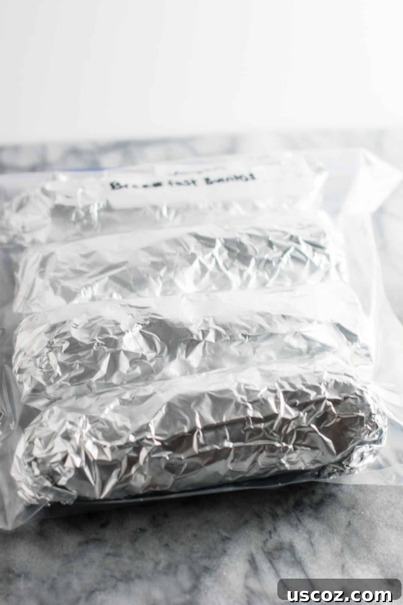 Plant-Based Breakfast Burrito Bliss 13 A stack of foil-wrapped vegan breakfast burritos, ready for the freezer.