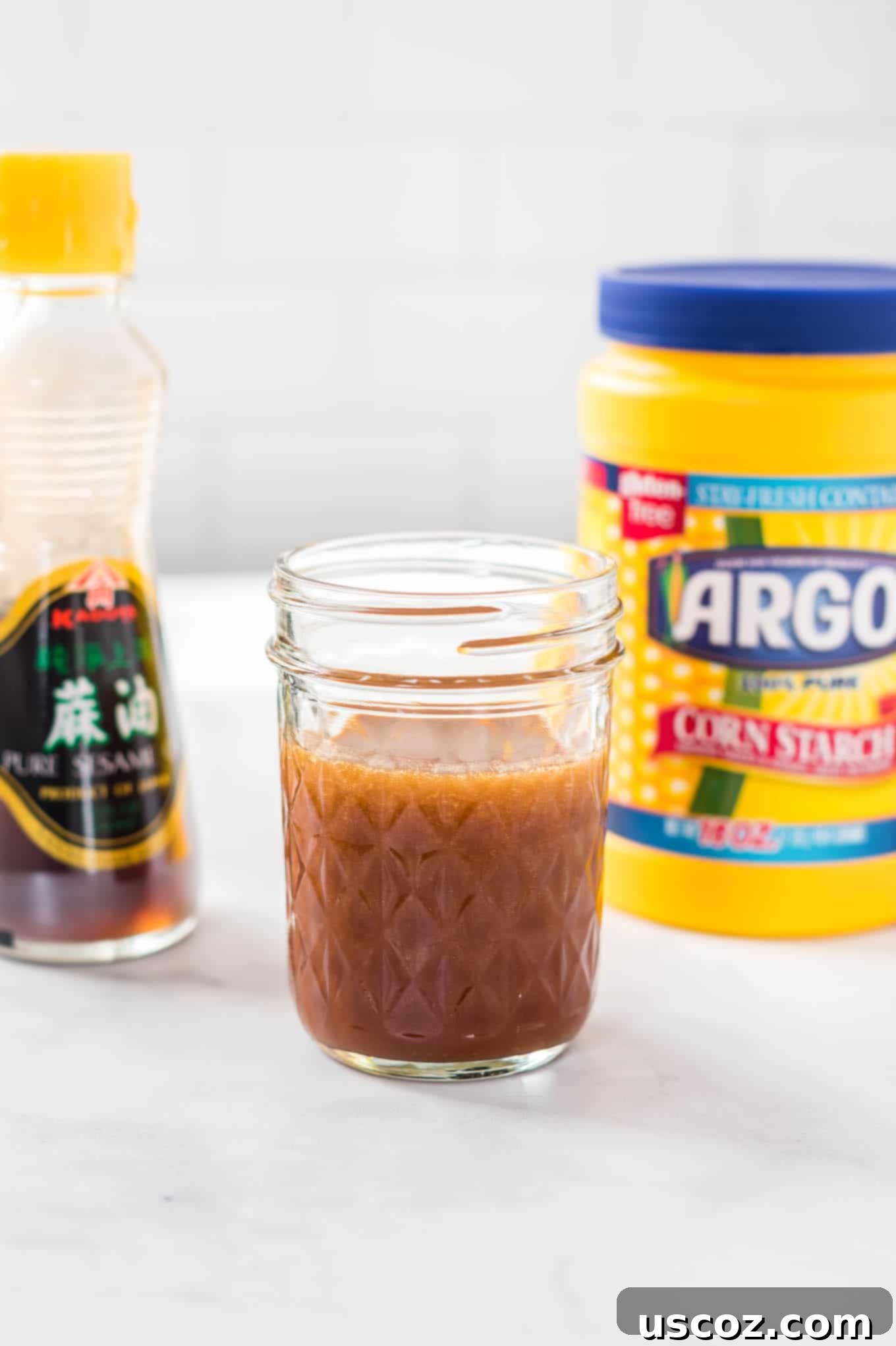 Perfect Stir Fry Sauce 11 sauce in a jar with sesame oil and corn starch in the back ground