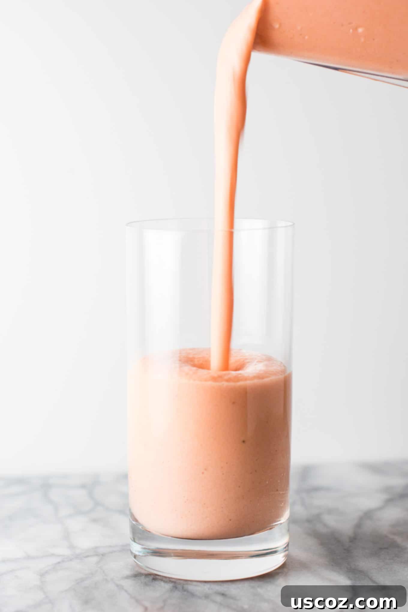 Carrot Cake Dream 5 smoothie being poured into a glass from a blender