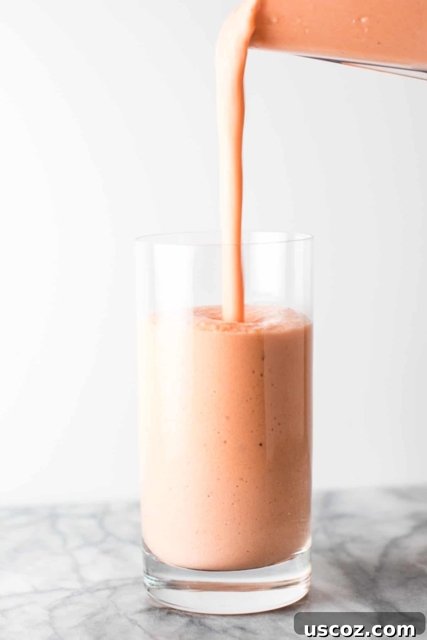 Carrot Cake Dream 6 smoothie being poured into a glass from a blender, 3/4 of the way full