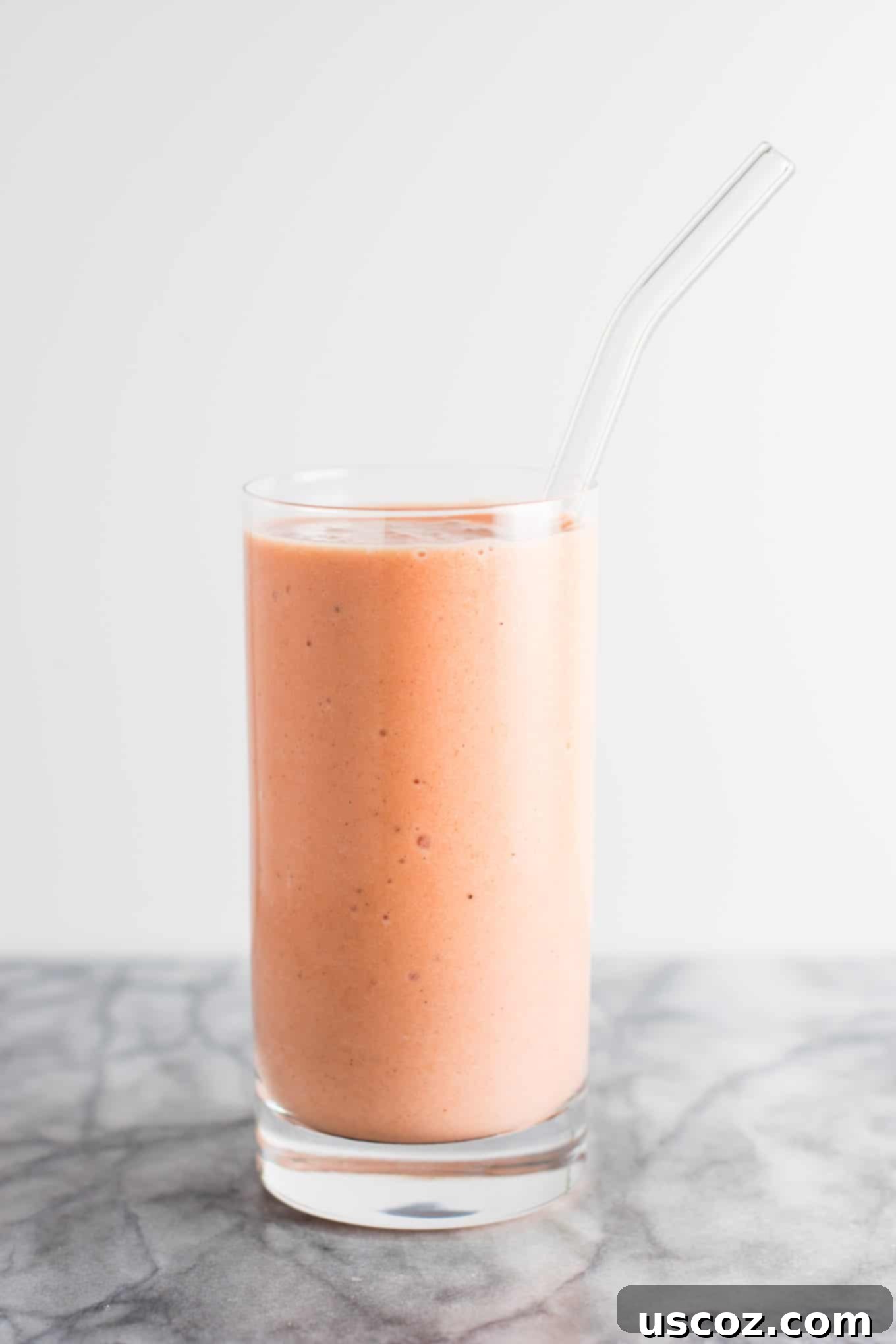 Carrot Cake Dream 9 carrot cake smoothie in a glass with a glass straw