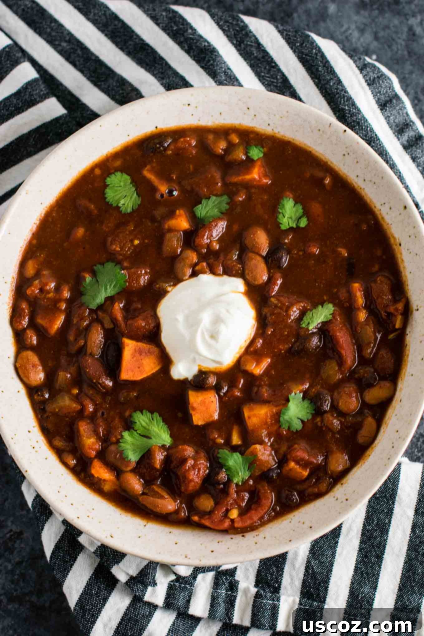 Easy Slow Cooker Vegetarian Sweet Potato Chili 11 A close-up shot of the rich, thick texture of the Slow Cooker Vegetarian Sweet Potato Chili in a bowl, ready to eat.