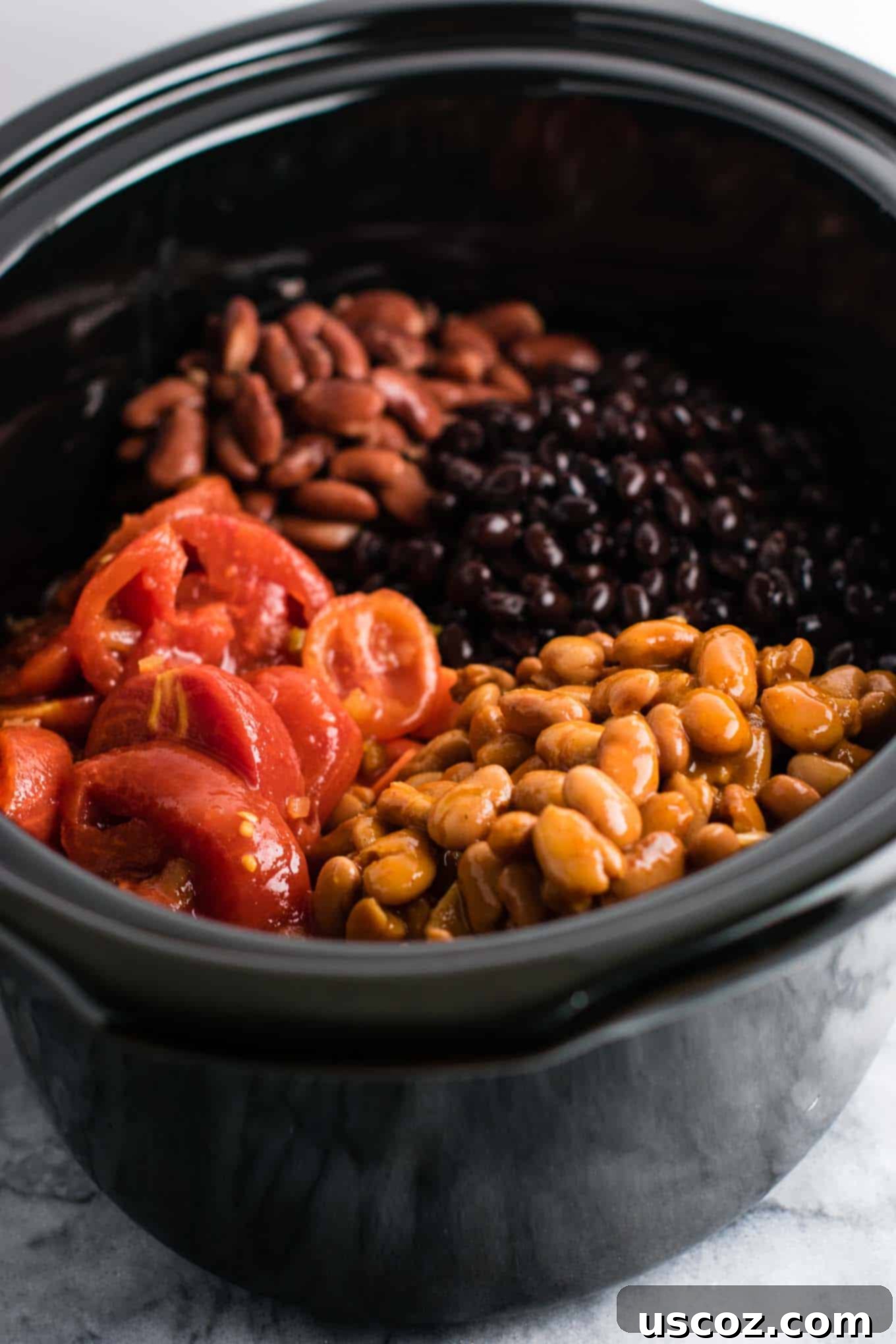 Easy Slow Cooker Vegetarian Sweet Potato Chili 5 All the dry and canned ingredients, including beans, diced tomatoes, and spices, are combined in a slow cooker, ready for cooking.