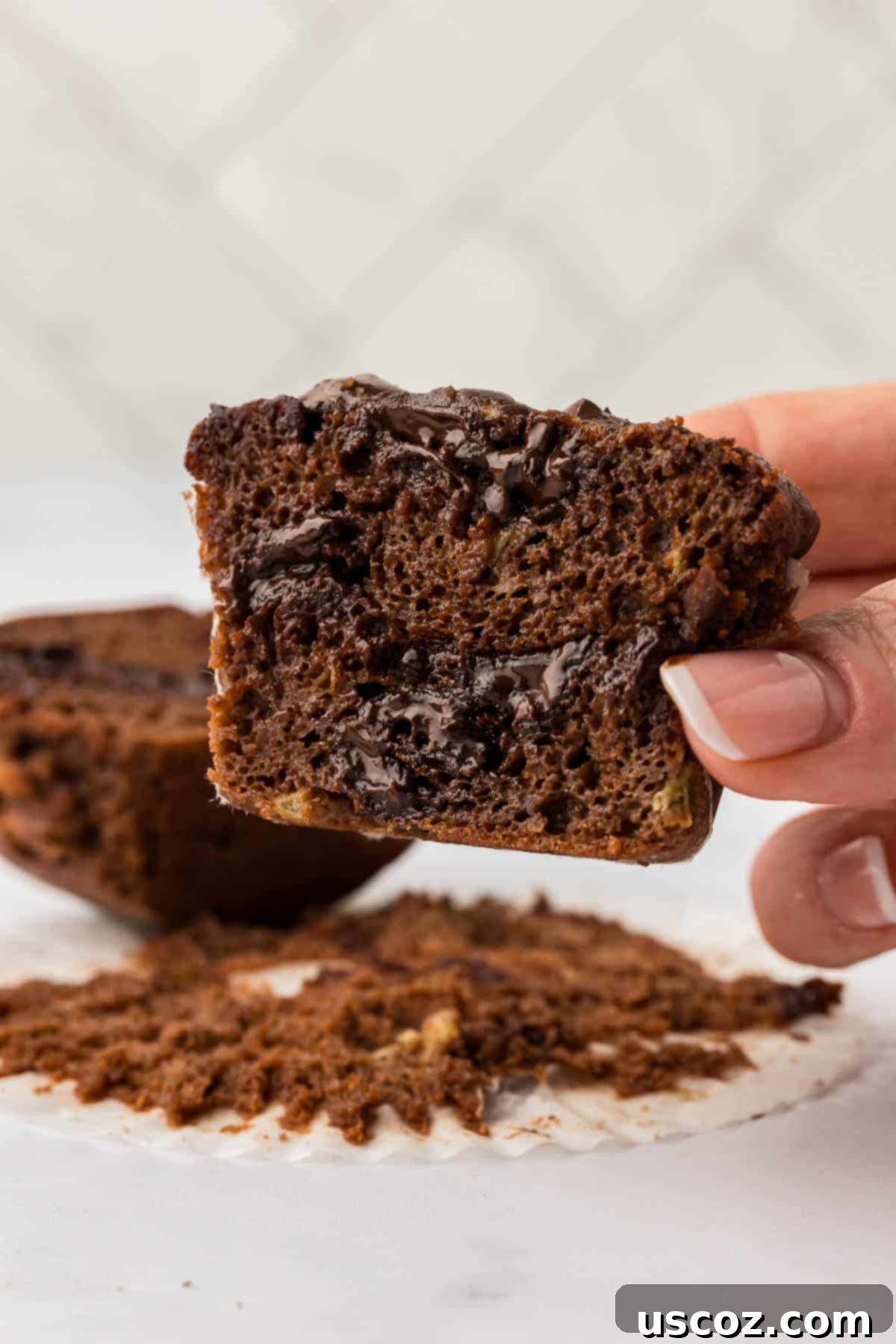 Nourishing Chocolate Muffins 19 Holding a healthy chocolate muffin cut open to show its moist texture and chocolate chips