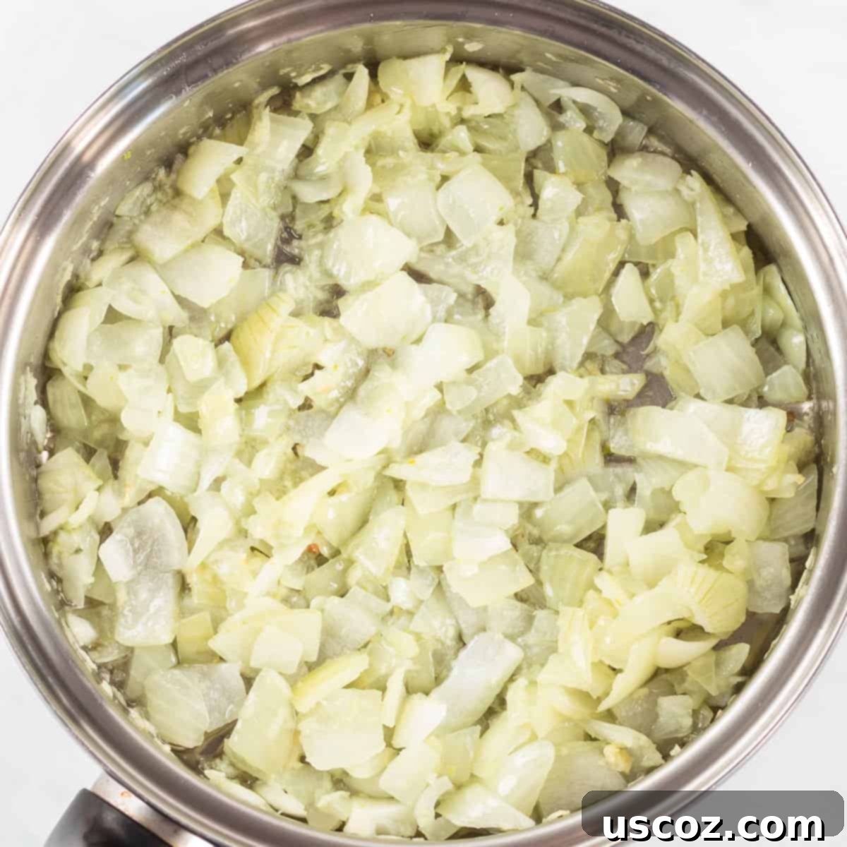 Garden Harvest Pie 5 The diced onion and minced garlic are perfectly sauteed and translucent in a skillet, indicating they are ready for the next ingredients.