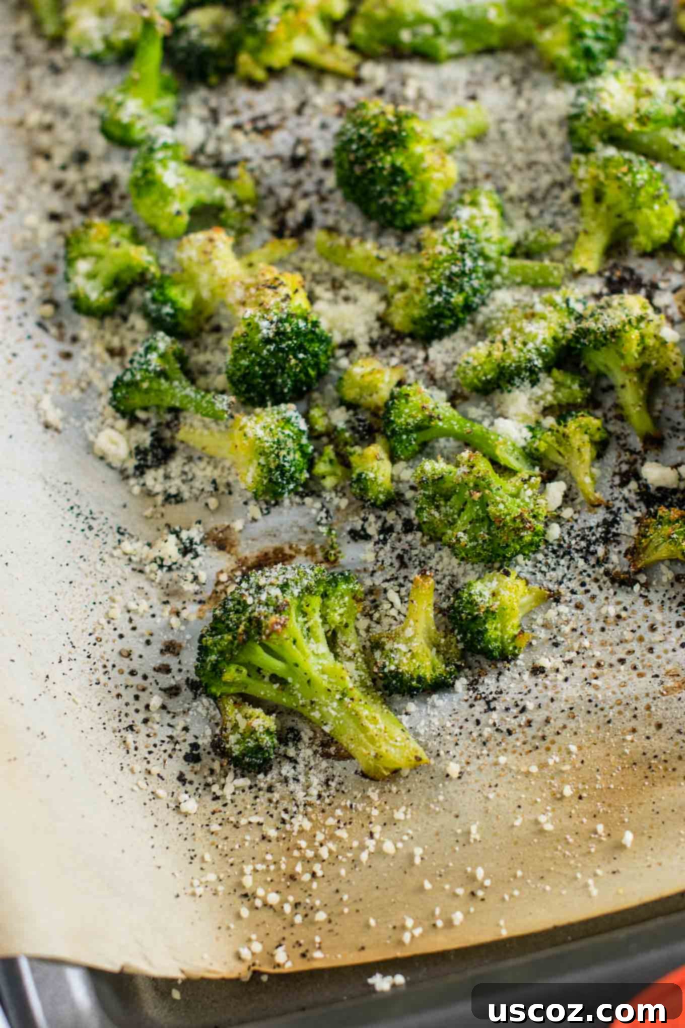 Perfectly Roasted Frozen Broccoli 5 Close-up of finished roasted frozen broccoli sprinkled with Parmesan cheese on a baking sheet.