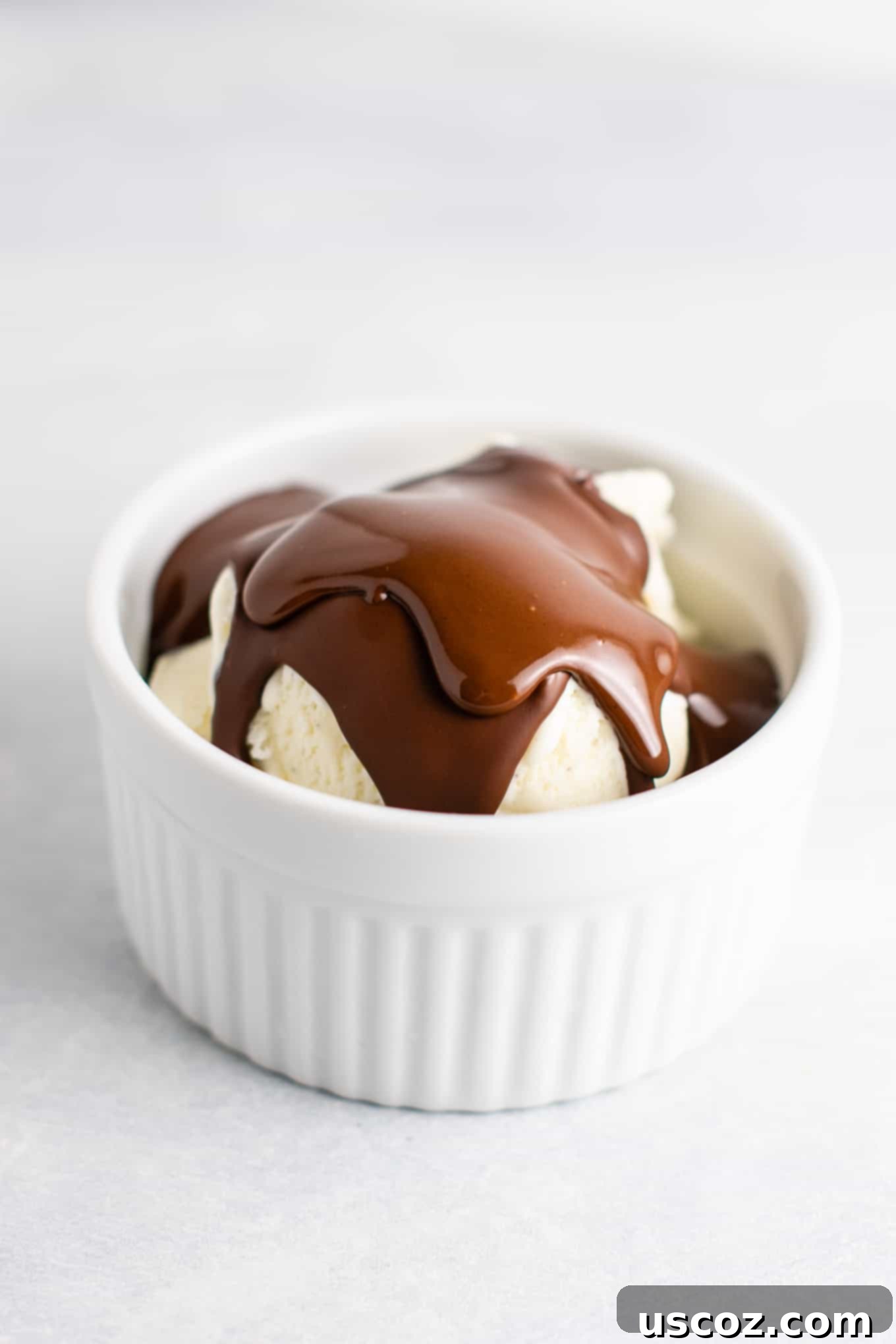 Homemade chocolate peanut butter magic shell poured over ice cream for a delightful treat.