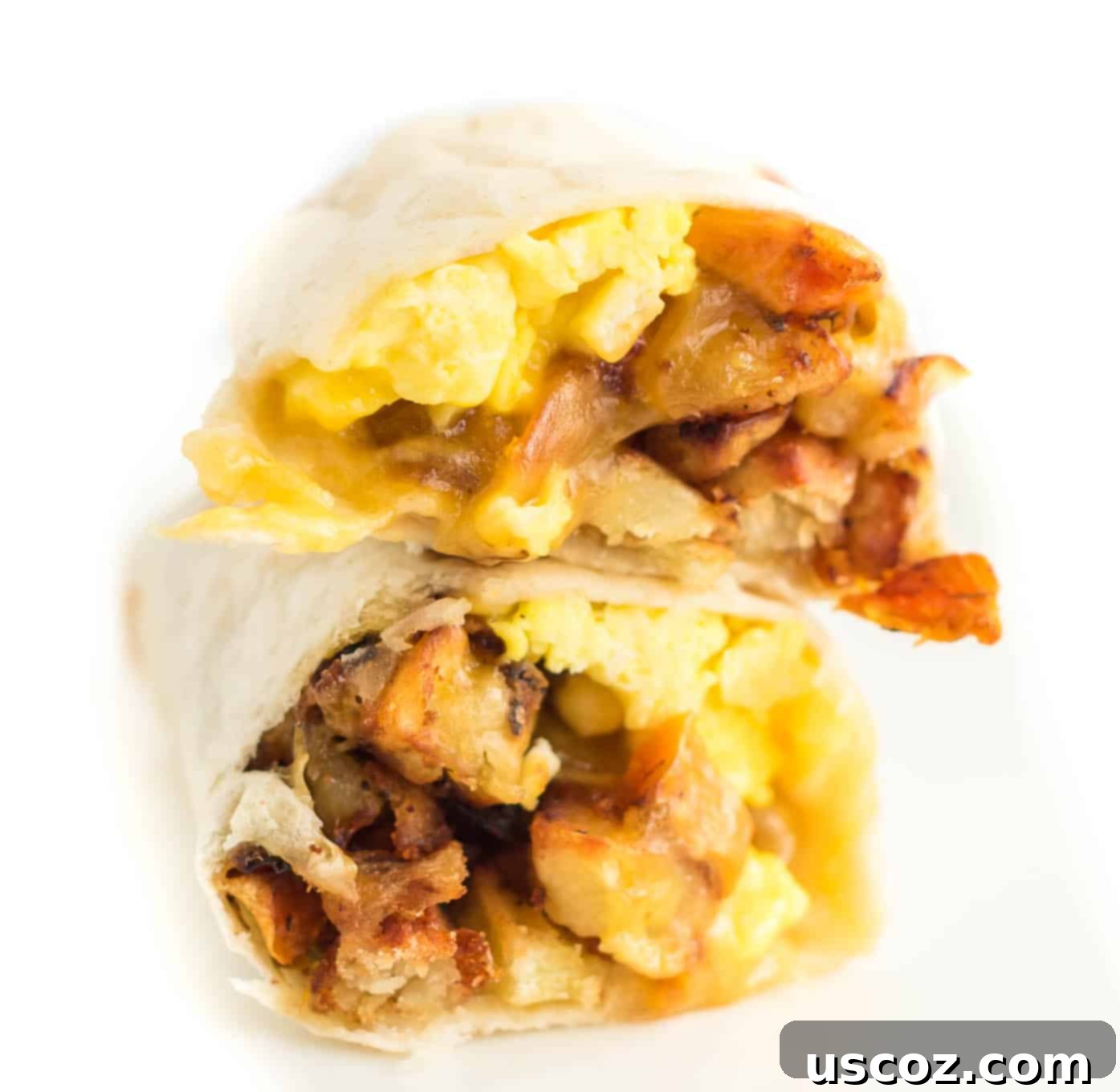 Your New Favorite Breakfast Burrito 4 Two breakfast burritos cut in half and stacked on top of each other, showcasing the layers of filling