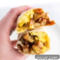 Your New Favorite Breakfast Burrito 10 a hand holding a breakfast burrito cut open