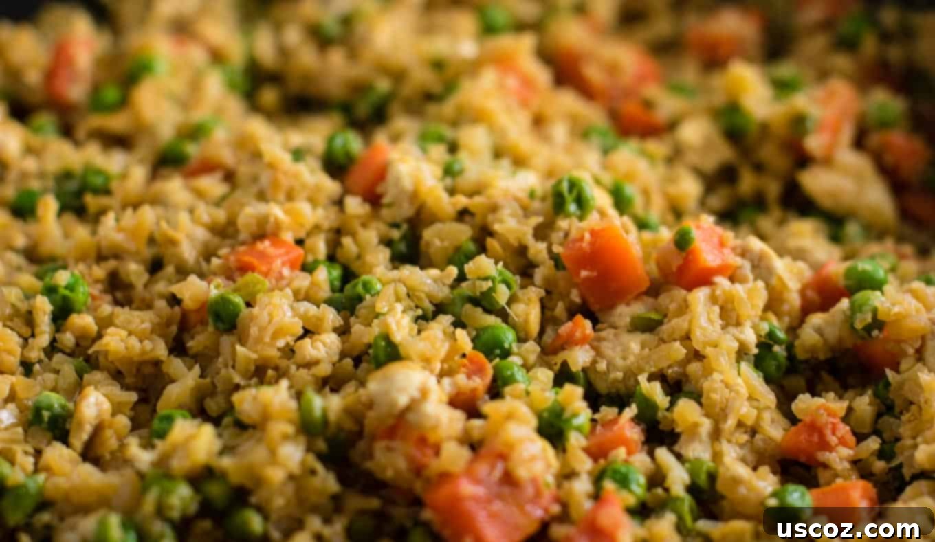Wholesome Cauliflower Tofu Fried Rice 6 A close-up of riced cauliflower cooking in a large skillet with other vegetables, demonstrating the base for this grain-free fried rice.