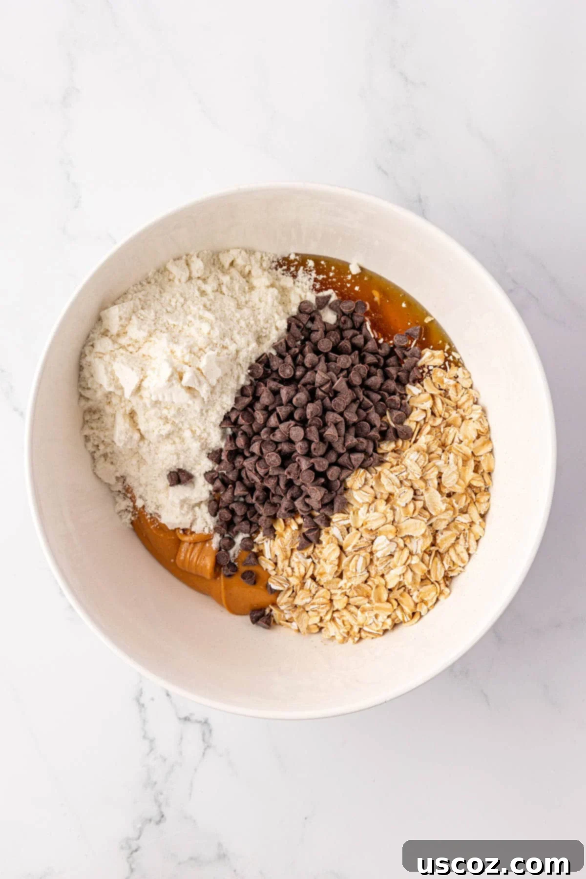 PB & Chocolate Chip Protein Bars 5 All protein bar ingredients added to a large mixing bowl, ready to be combined.