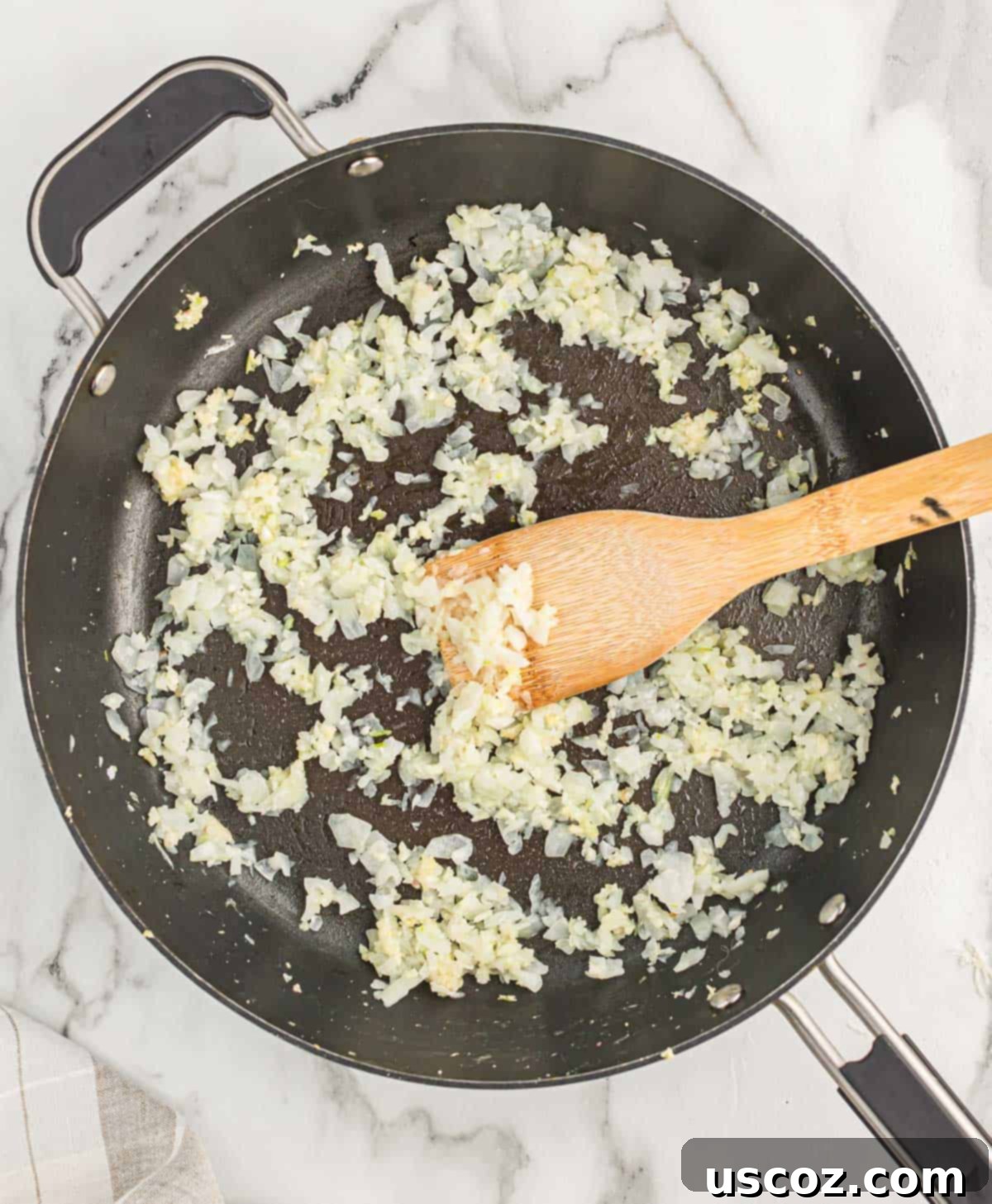 The Ultimate Baked Spinach Artichoke Dip 5 Onion and garlic sizzling in olive oil in a stainless steel skillet