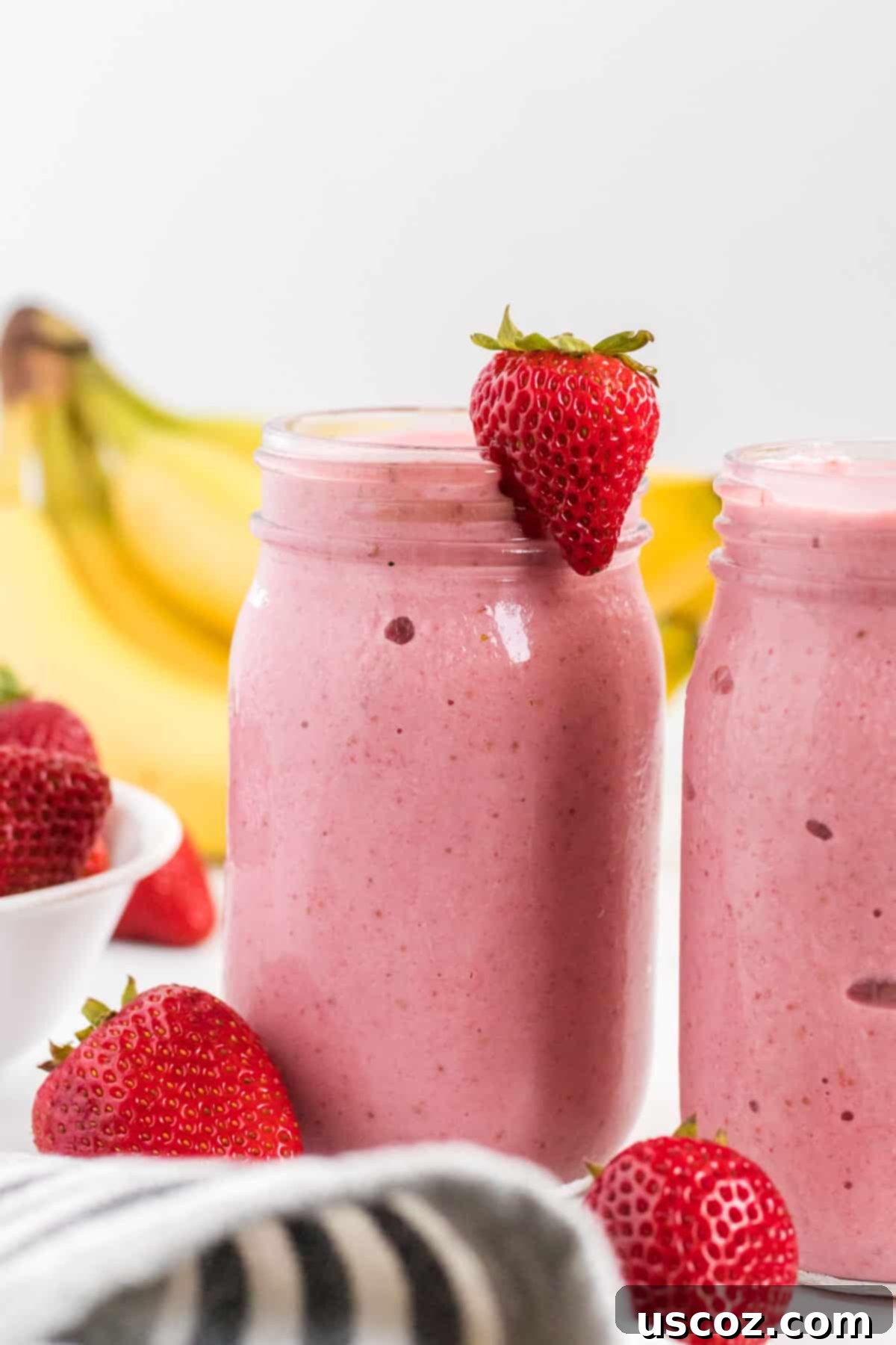 Sweet Strawberry Banana Bliss 2 strawberry banana smoothie in a mason jar with a strawberry on the rim