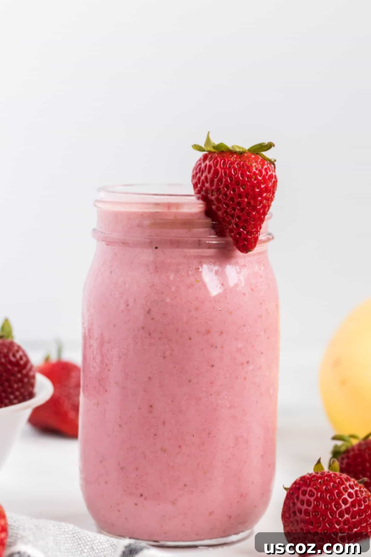 Sweet Strawberry Banana Bliss 9 strawberry banana smoothie in a mason jar with a strawberry on the rim