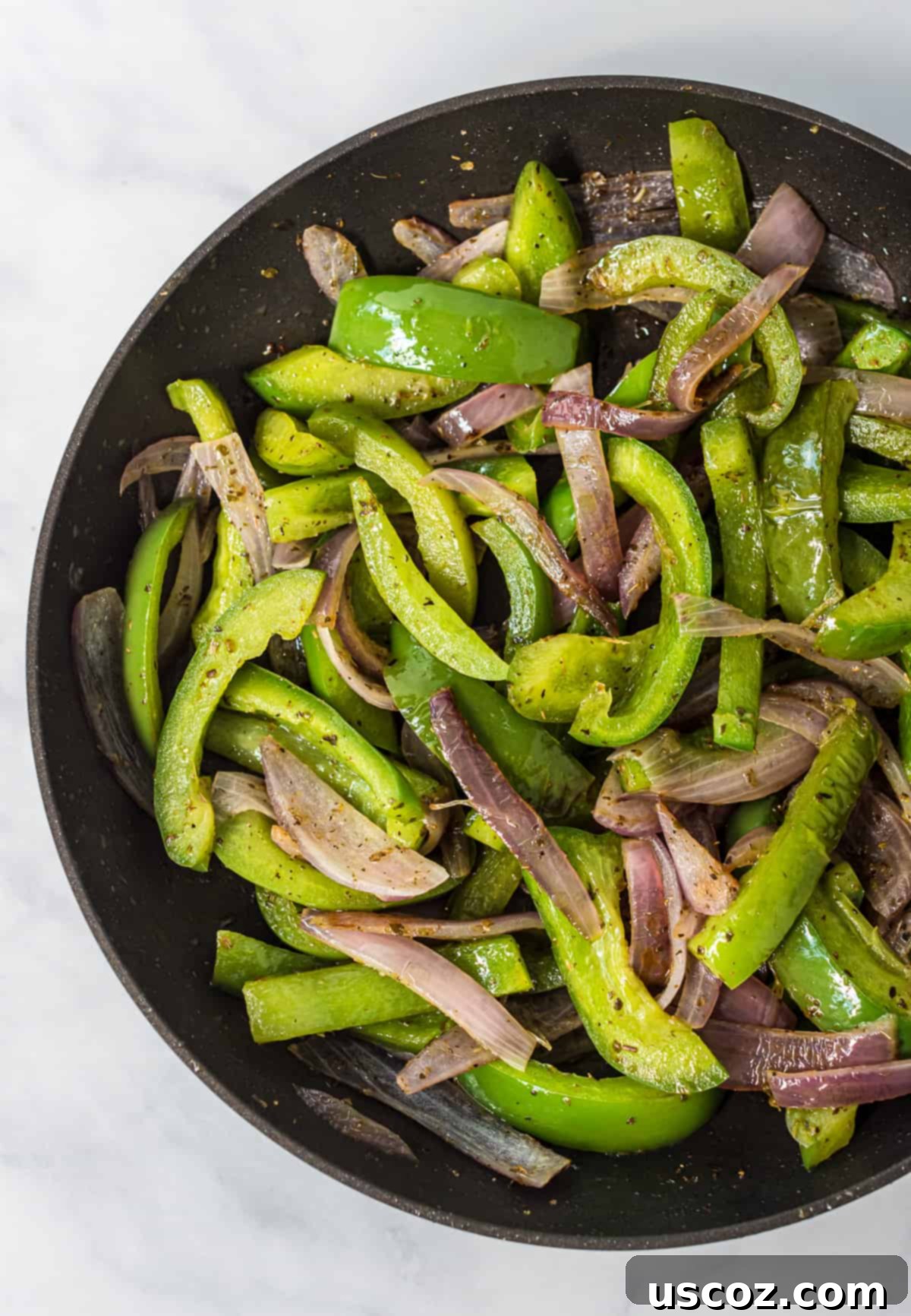 Plant-Powered Mexican Feasts 7 Cooked fajita veggies, including colorful bell peppers and onions, sizzling in a skillet