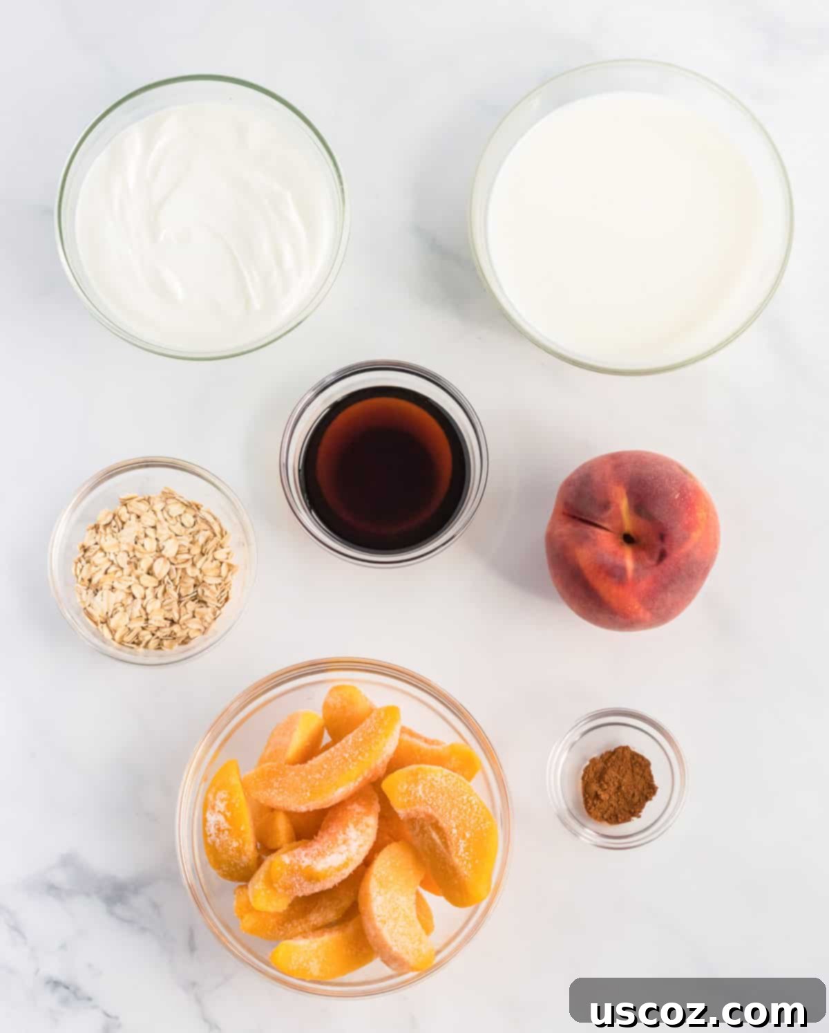 Wholesome Peach Smoothie 3 Collection of fresh ingredients arranged for making a peach smoothie: frozen peaches, a whole fresh peach, Greek yogurt, milk, cinnamon, rolled oats, and maple syrup.