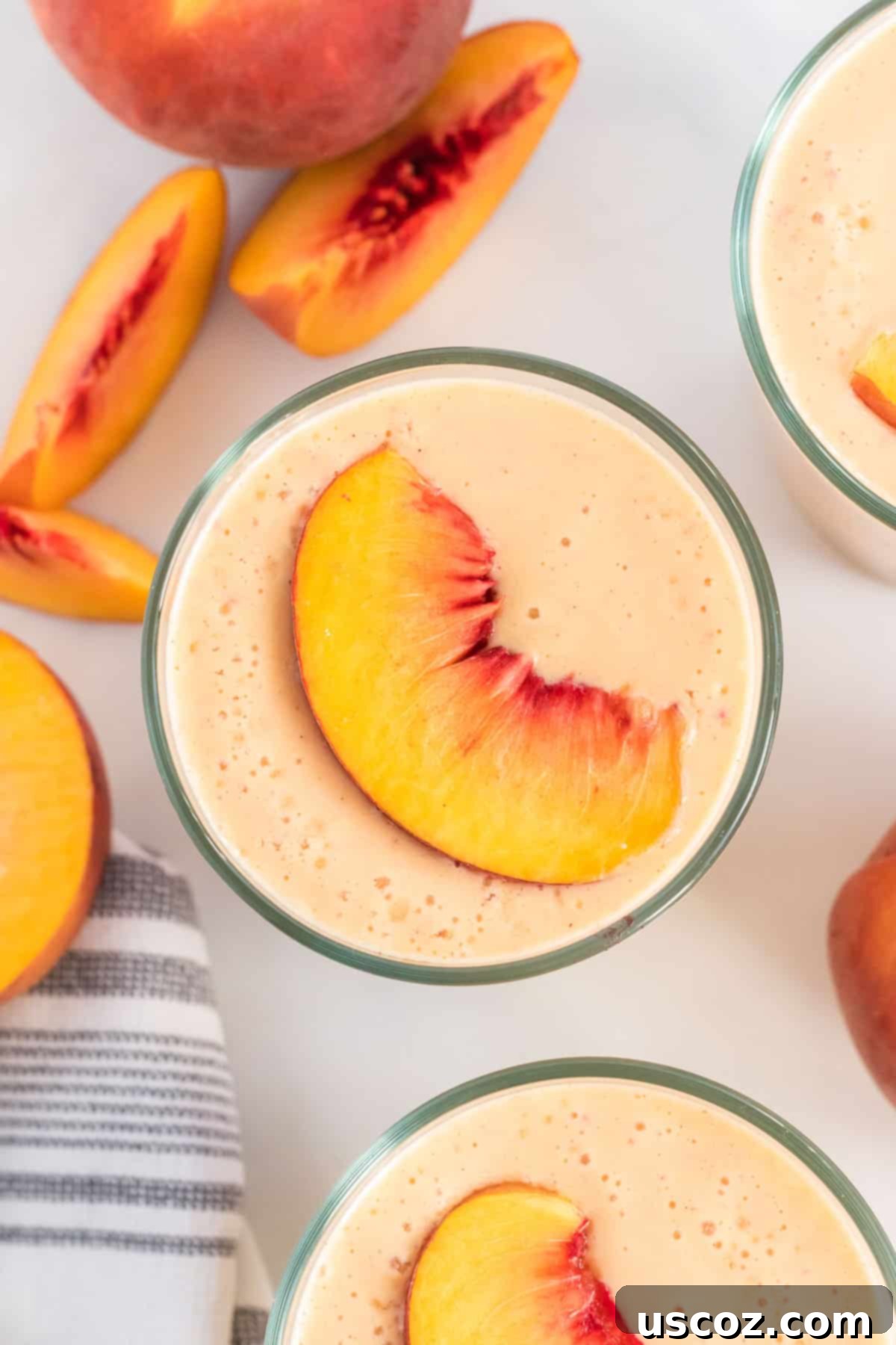 Wholesome Peach Smoothie 8 Two elegant glasses of creamy peach smoothies, beautifully garnished with fresh peach slices on top, presenting a delightful and healthy beverage.