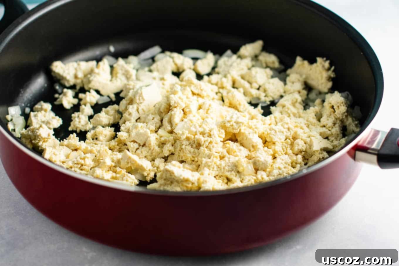Wholesome Tofu Scramble 6 Seasoning the tofu scramble with turmeric, nutritional yeast, and paprika for color and flavor. #tofuscramblerecipe #plantbased