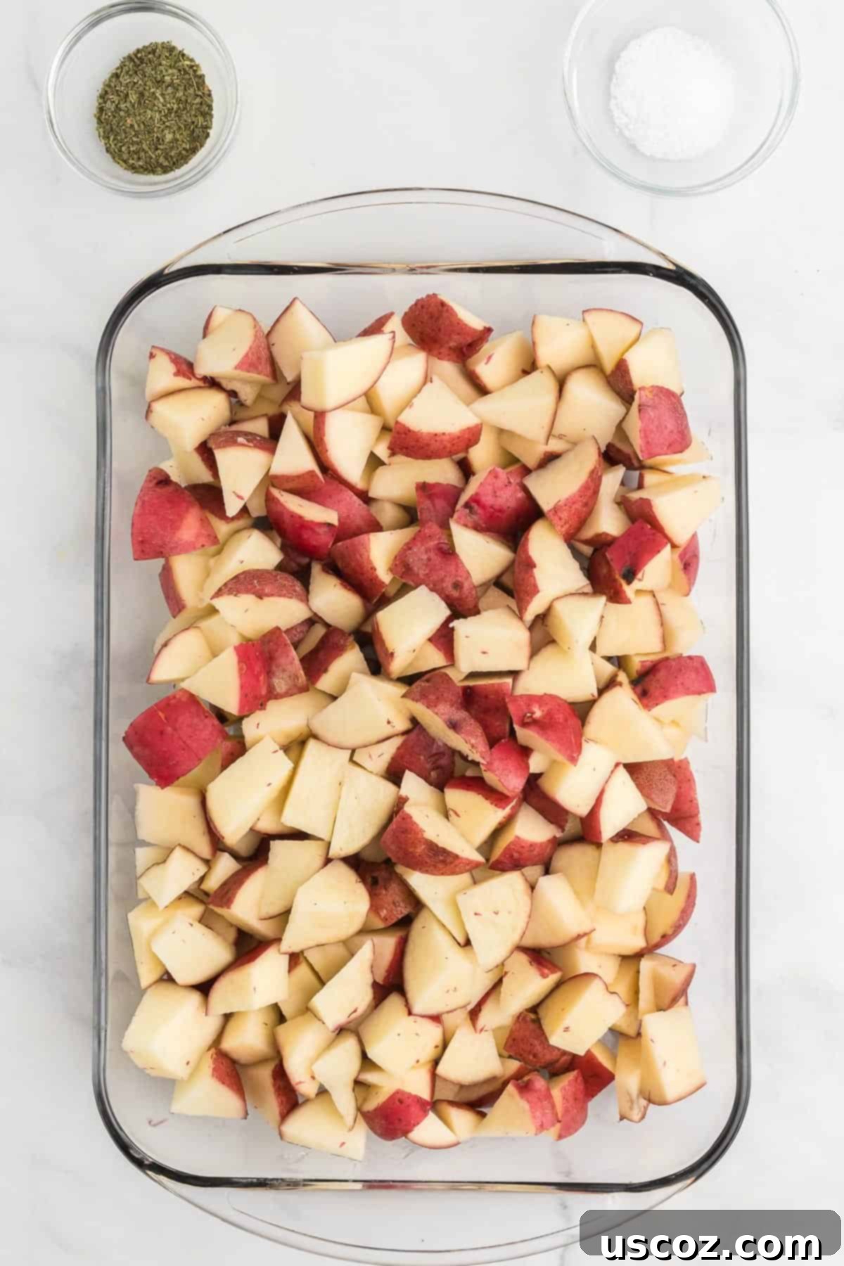 Garlic Herb Roasted Baby Red Potatoes 5 diced baby red potatoes in a glass baking dish, ready for seasoning