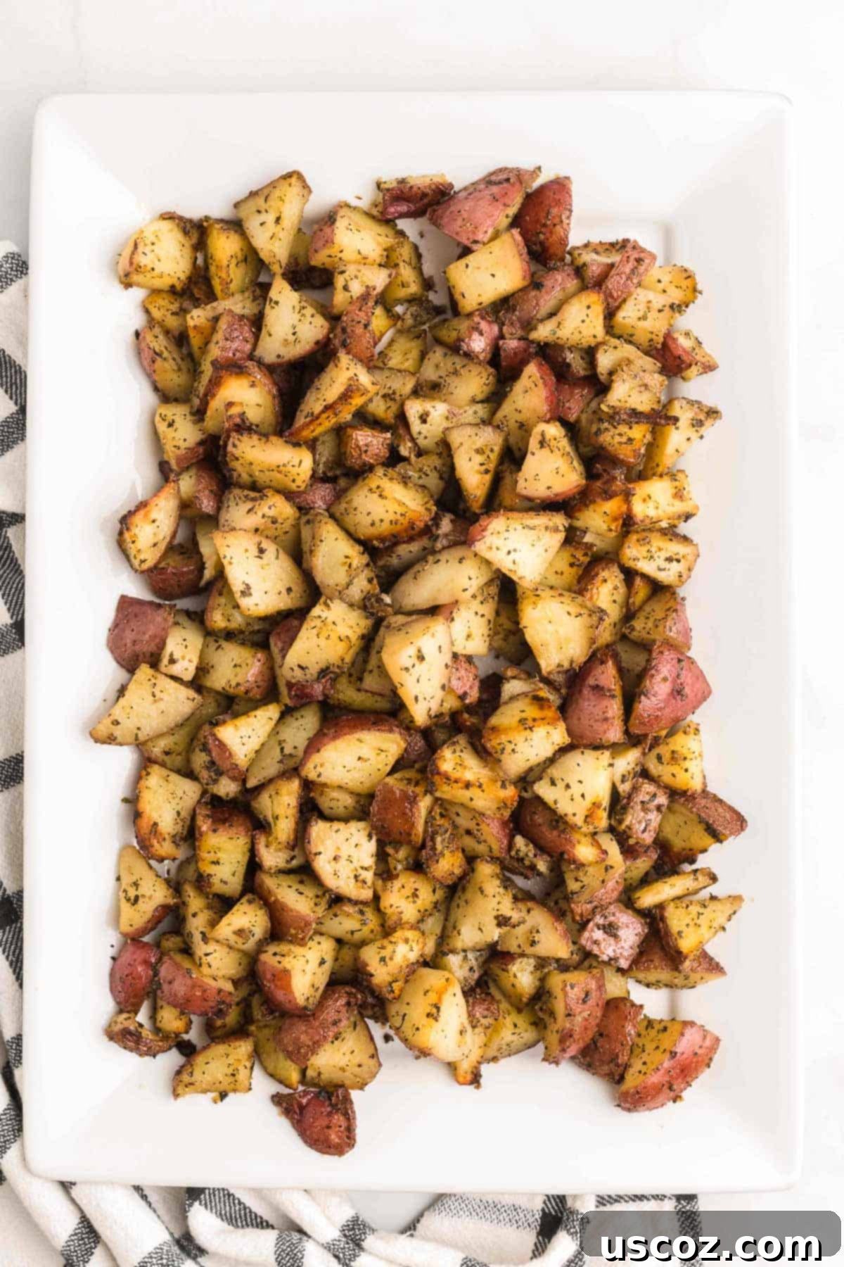 Garlic Herb Roasted Baby Red Potatoes 9 a generous serving of roasted red potatoes on a white plate, ready to be enjoyed