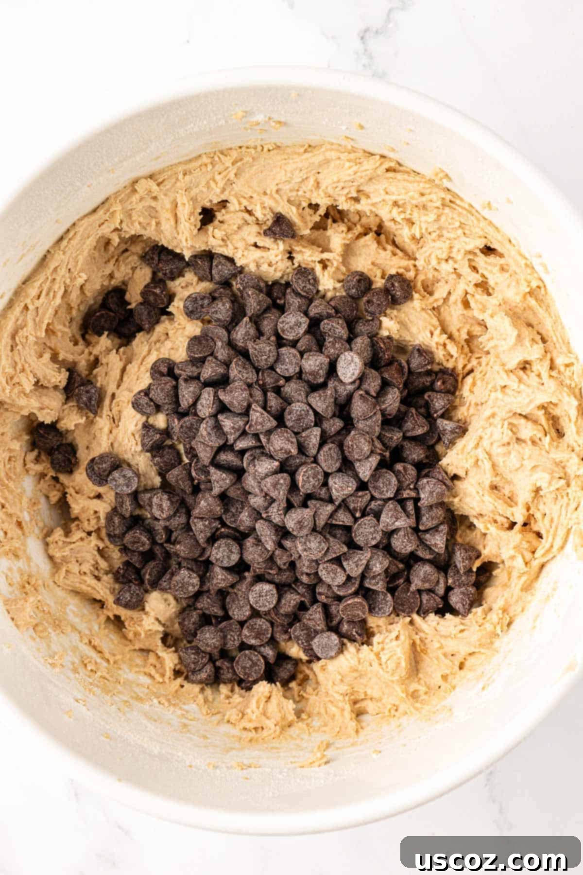 Delicious Vegan Chocolate Chip Cookies 11 chocolate chips being poured into the cookie batter