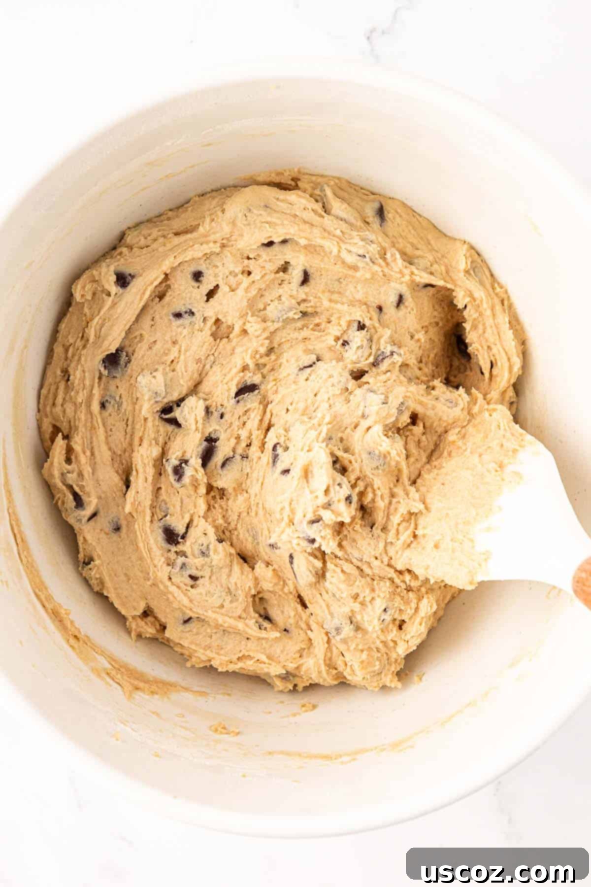 Delicious Vegan Chocolate Chip Cookies 12 a spatula gently folding chocolate chips into the cookie batter