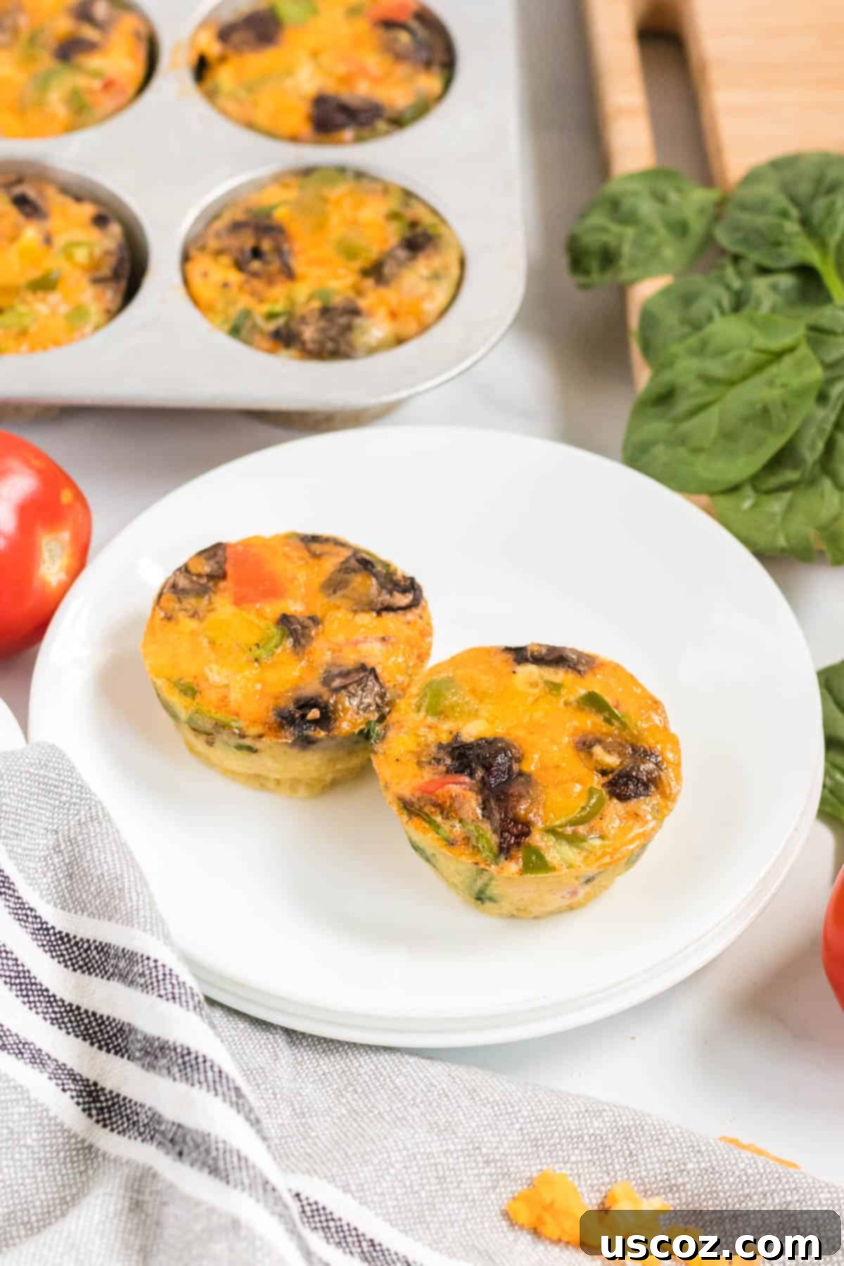 Savory Egg Muffins 8 Two freshly cooked egg muffins on a white plate, highlighting their appetizing appearance.