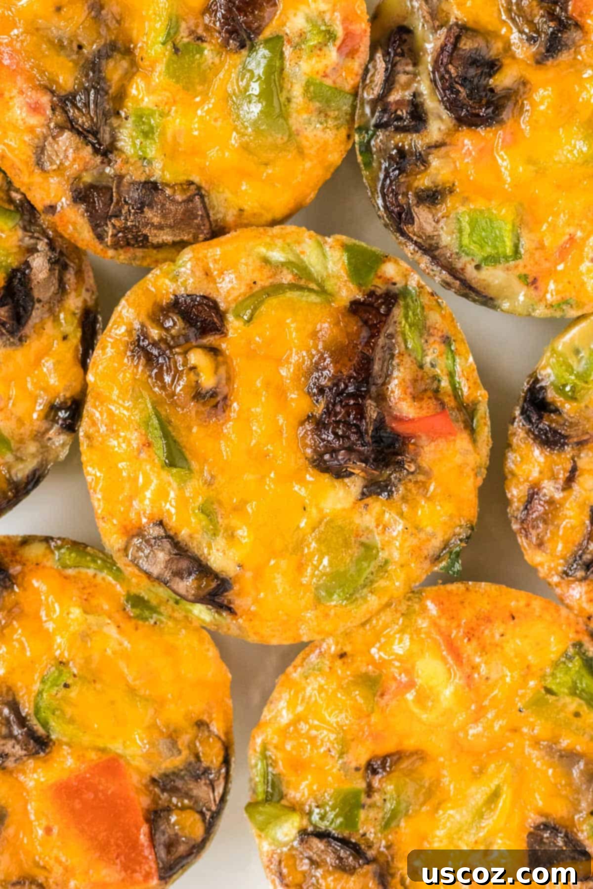 Savory Egg Muffins 10 A close-up shot of perfectly baked egg muffins, showcasing their golden tops and visible vegetable bits.