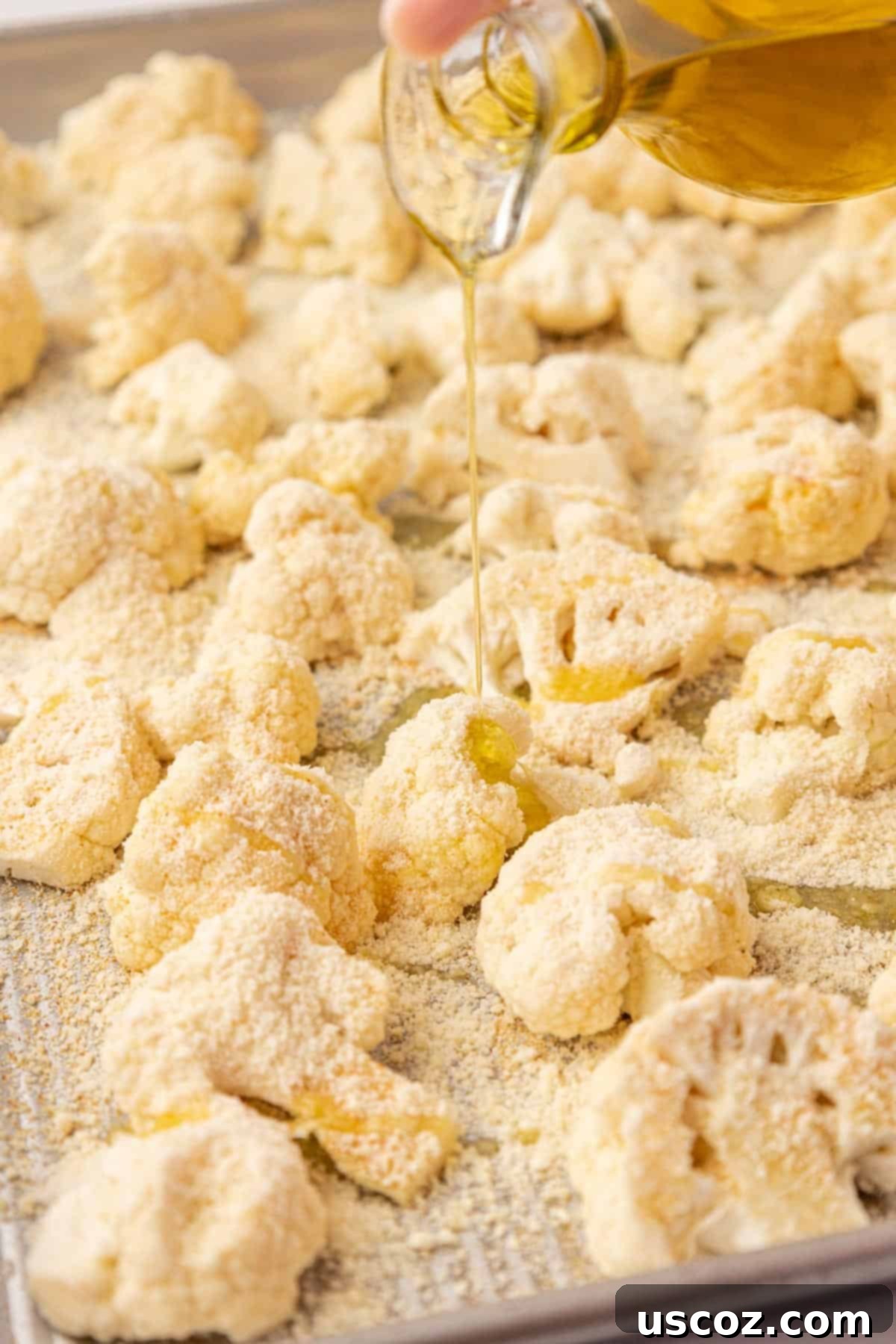Crispy Parmesan Roasted Cauliflower 7 pouring olive oil onto the cauliflower florets