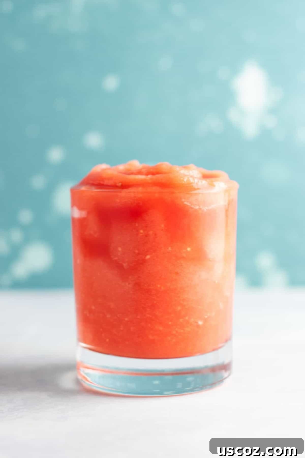 Closeup of a tropical gin slushie with fresh fruit garnish