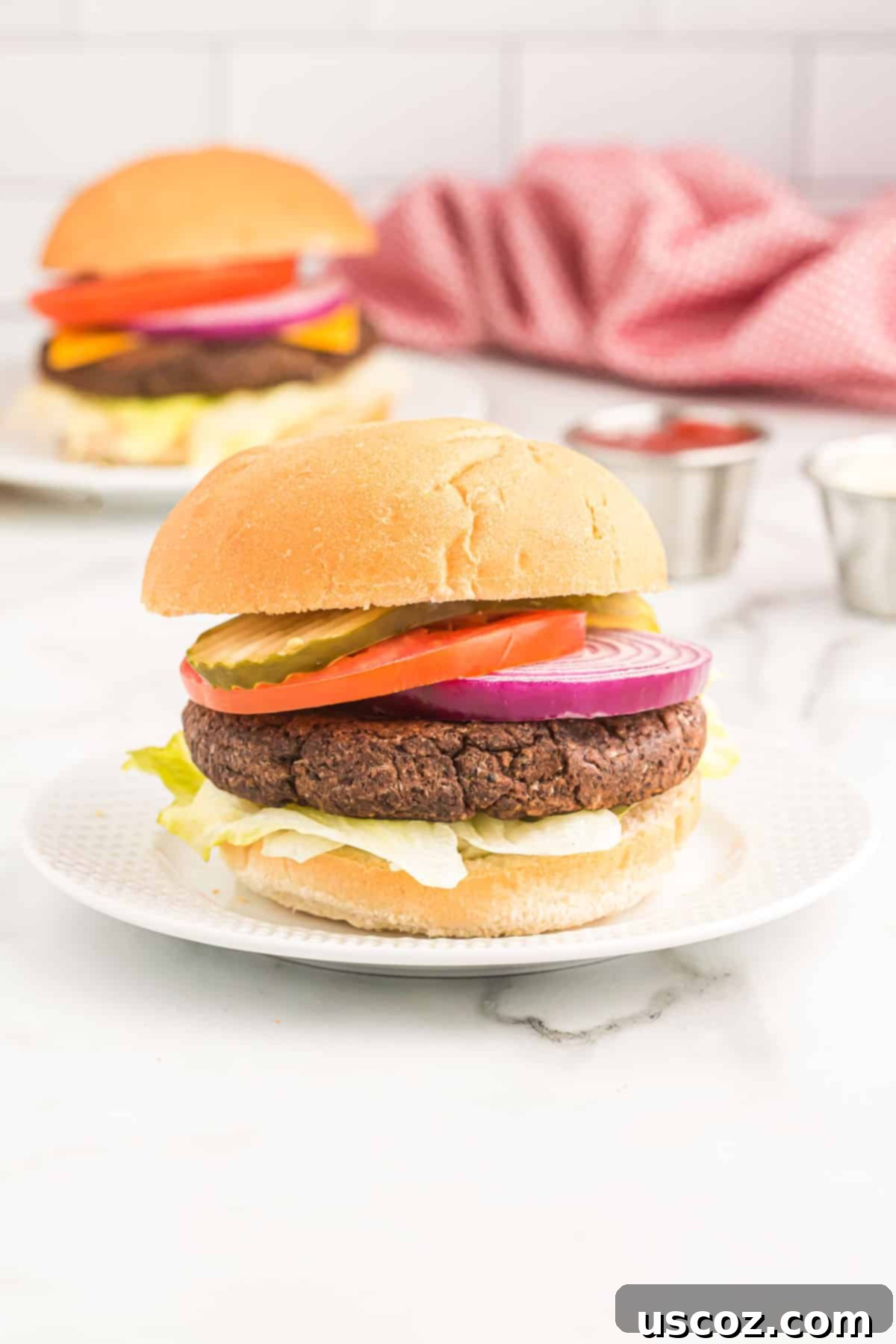 Ultimate Black Bean Burgers 2 mouth-watering black bean burger on a brioche bun with fresh pickles, ripe tomato slices, crisp lettuce, and vibrant red onion