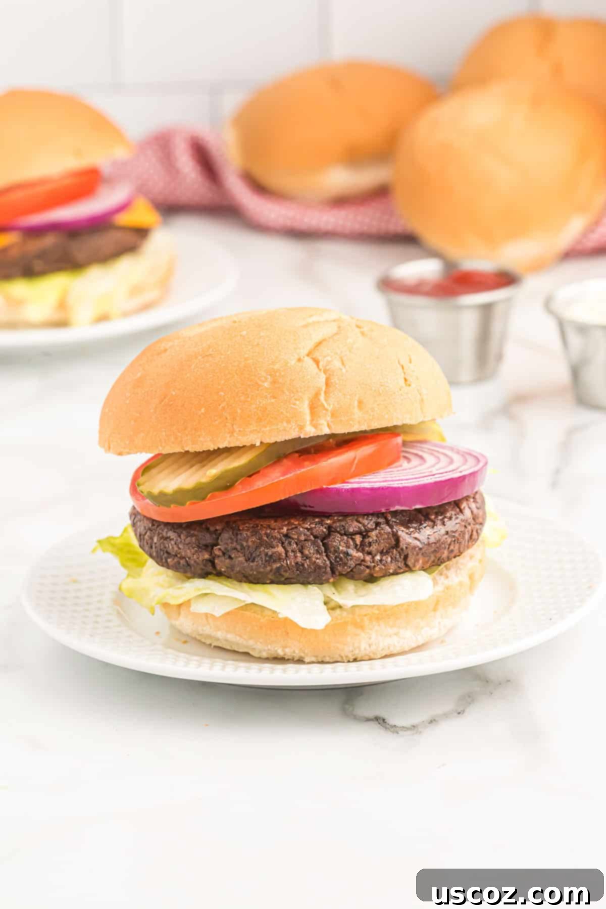 Ultimate Black Bean Burgers 11 a beautifully assembled black bean burger on a bun, generously topped with crisp lettuce, juicy tomato, red onion, and tangy pickles