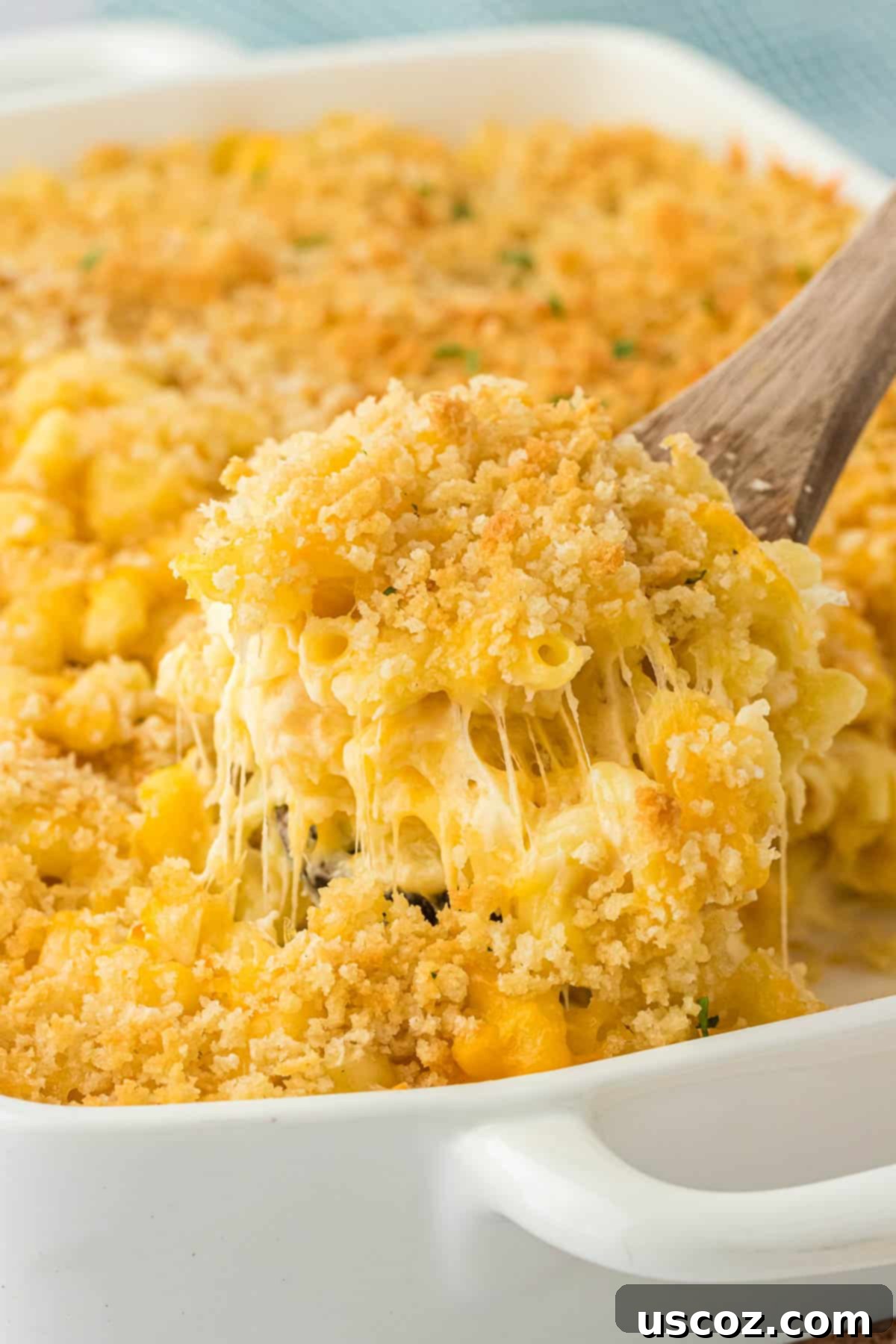 Golden Baked Macaroni Perfection 3 scooping mac and cheese from the baking dish