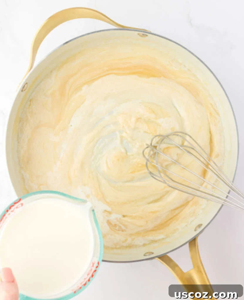 Golden Baked Macaroni Perfection 8 adding milk to the roux to make cheese sauce