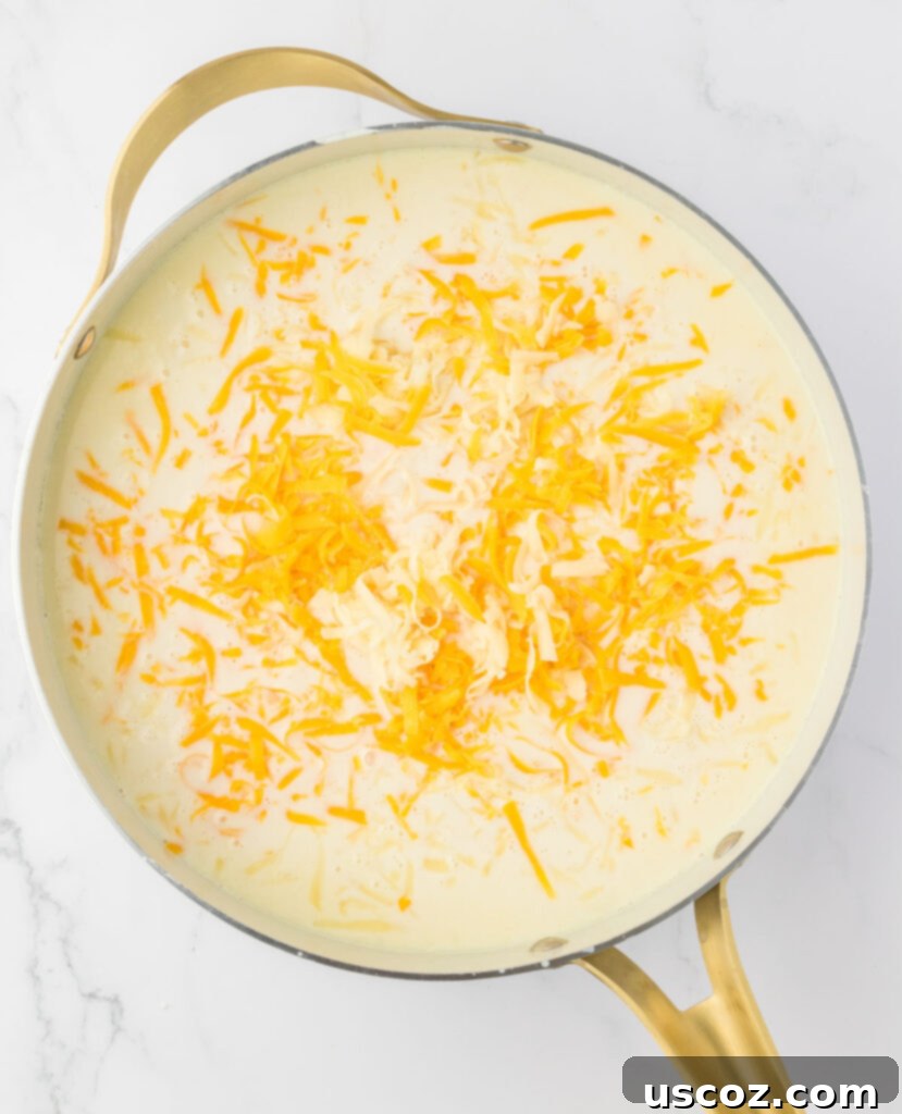 Golden Baked Macaroni Perfection 9 mac and cheese sauce thickening in a skillet