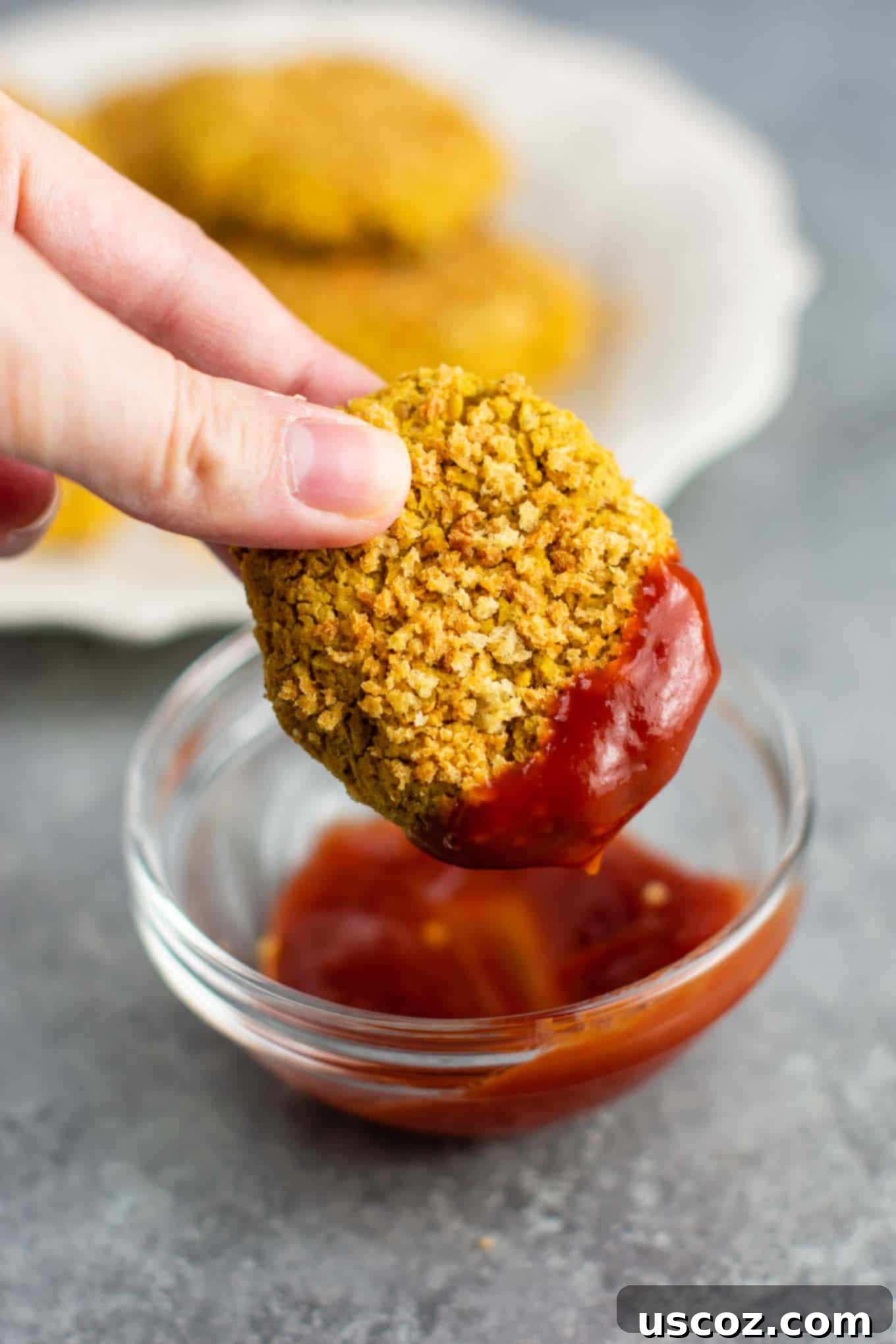 Golden Chickpea Poppers 2 Crispy homemade chickpea nuggets on a parchment-lined baking sheet, ready to be served as a meatless chicken nugget alternative.