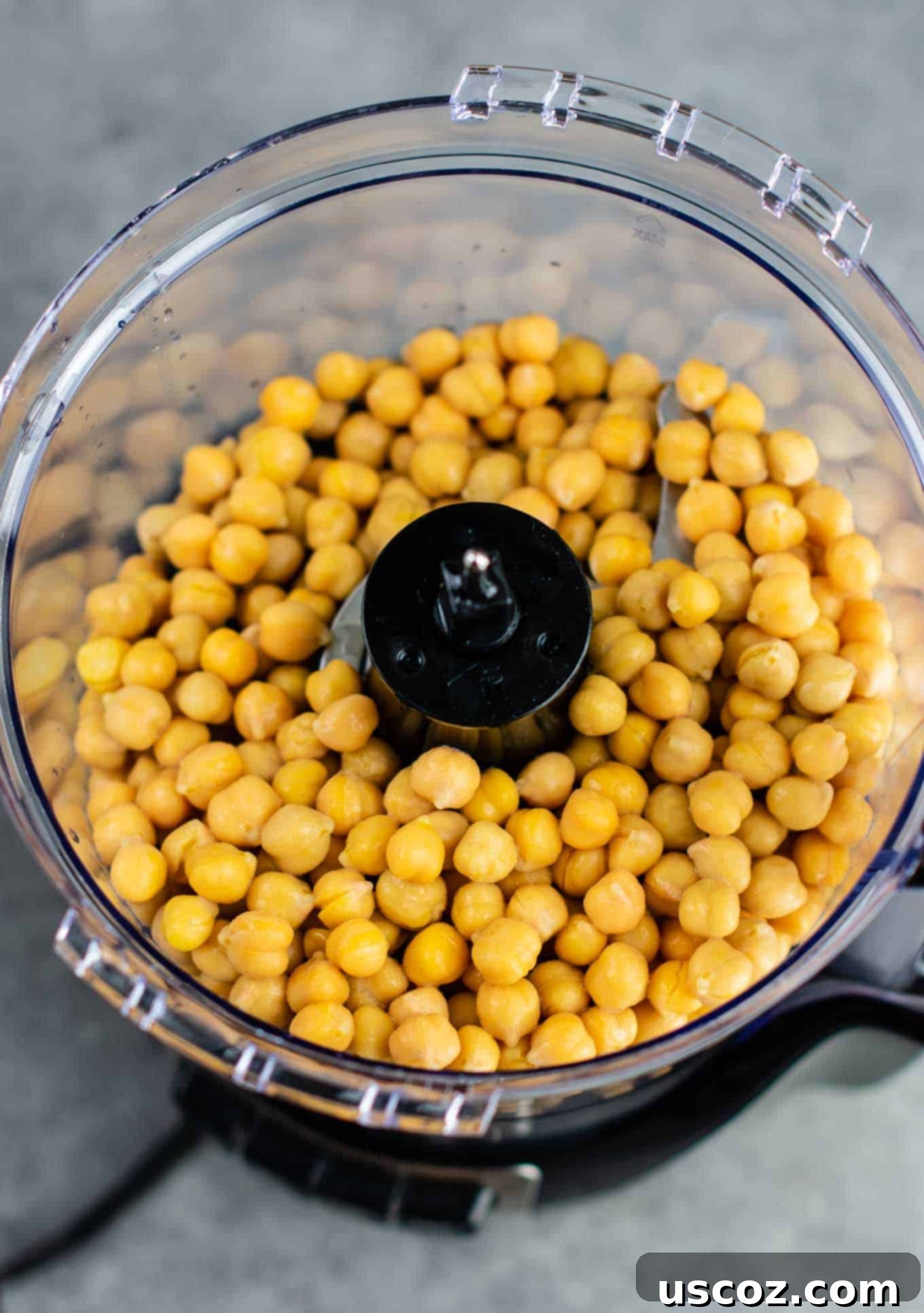 Golden Chickpea Poppers 4 Drained and rinsed chickpeas in a food processor, ready to be blended for a meatless chicken nugget recipe.