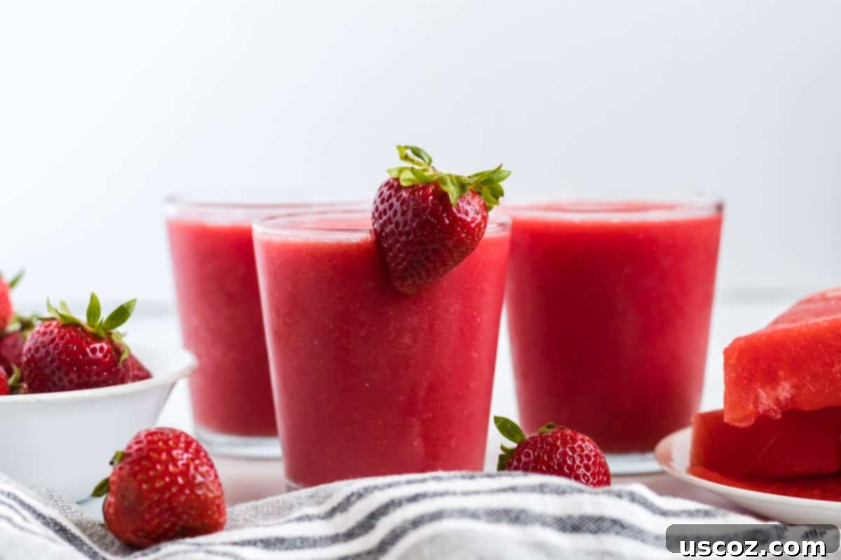Sweet Summer Smoothie Sensation 7 strawberry watermelon smoothie in a clear glass with a strawberry on the rim