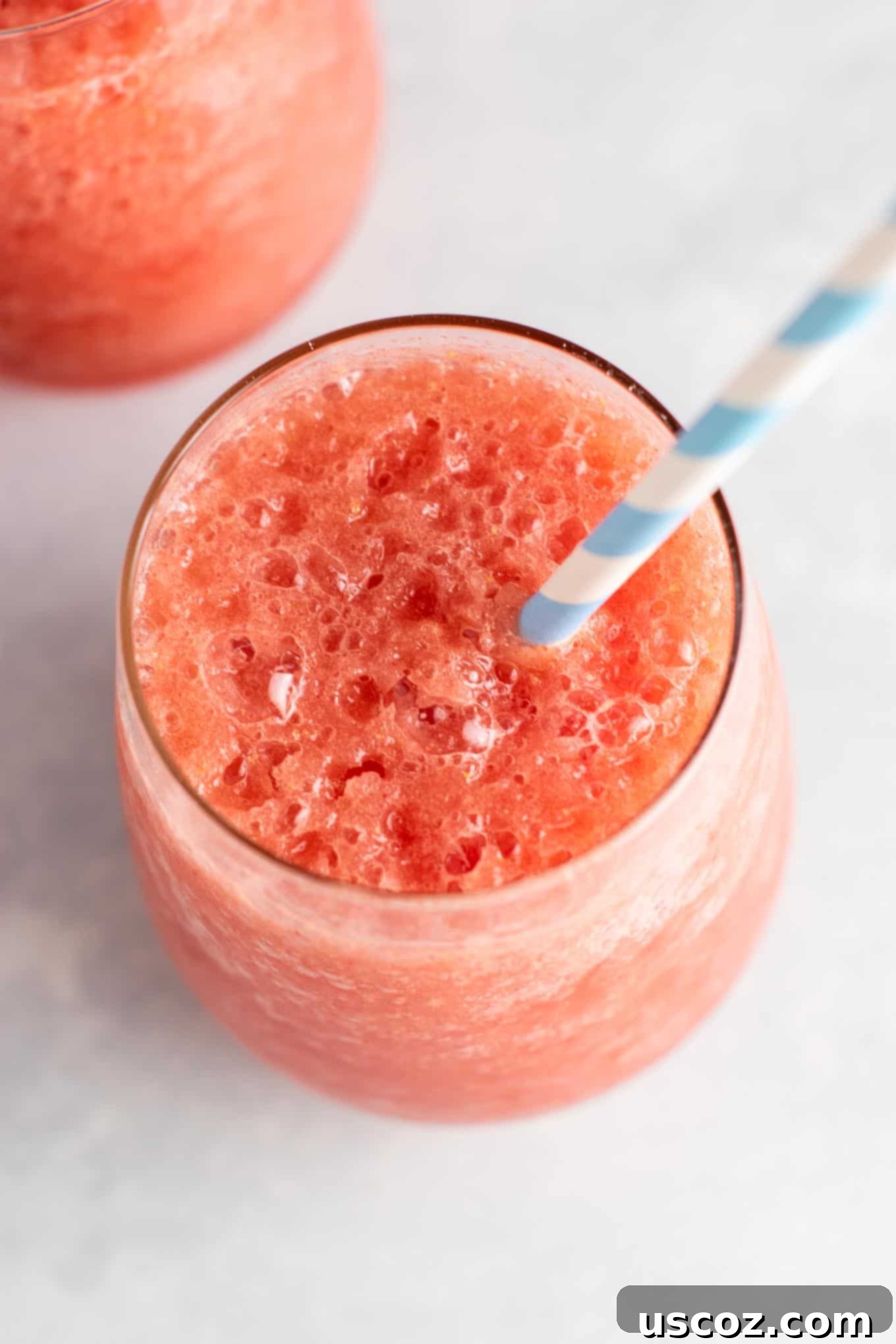 A pair of beautifully presented watermelon white wine slushies in elegant glasses, ready for a summer toast.