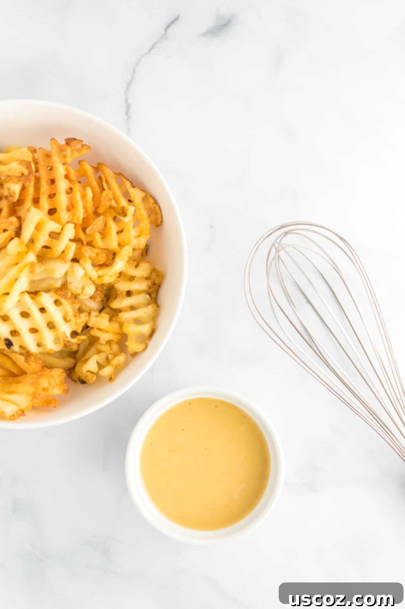 Make Your Own Chick-fil-A Sauce 4 A white ramekin filled with homemade Chick-fil-A sauce, accompanied by a bowl of waffle fries and a whisk