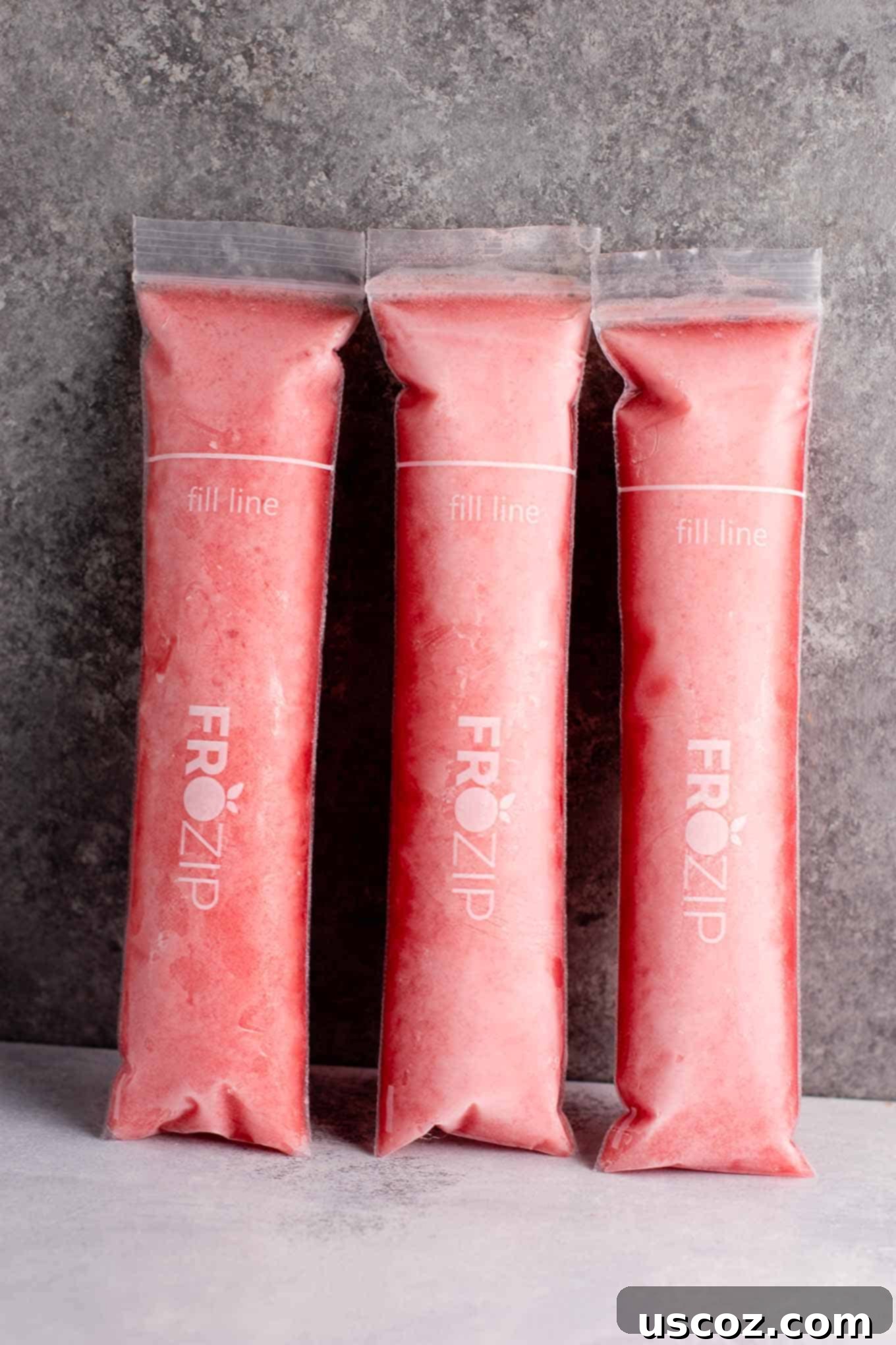 Close-up of a refreshing Strawberry Pineapple Freezer Pop, showcasing the natural colors and smooth texture, ready to be enjoyed as a healthy summer treat.